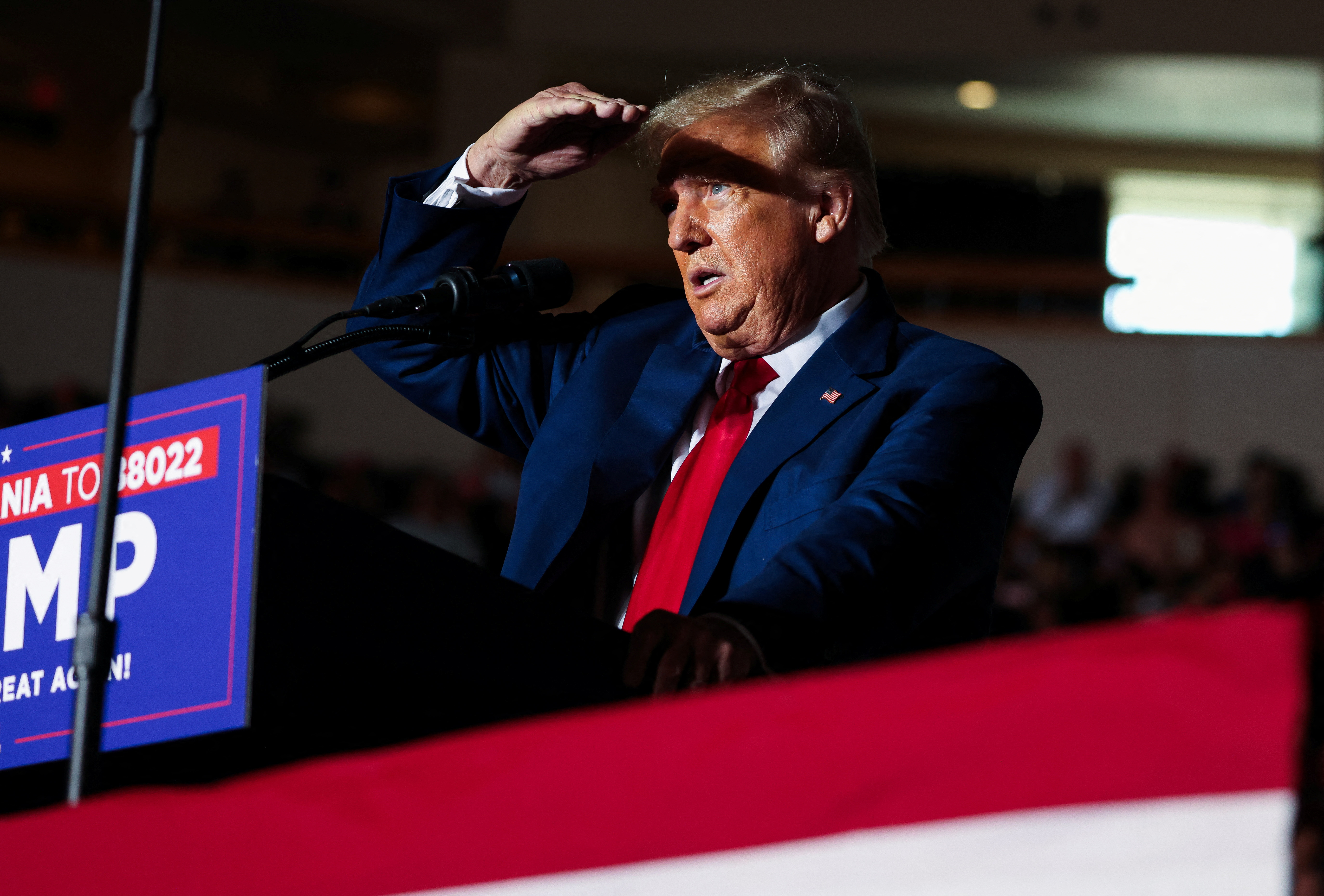 Former U.S. President and Republican presidential candidate Donald Trump covers his face from lights as he holds a campaign rally in Erie, Pennsylvania, U.S., July 29, 2023. REUTERS/Lindsay DeDario/File Photo