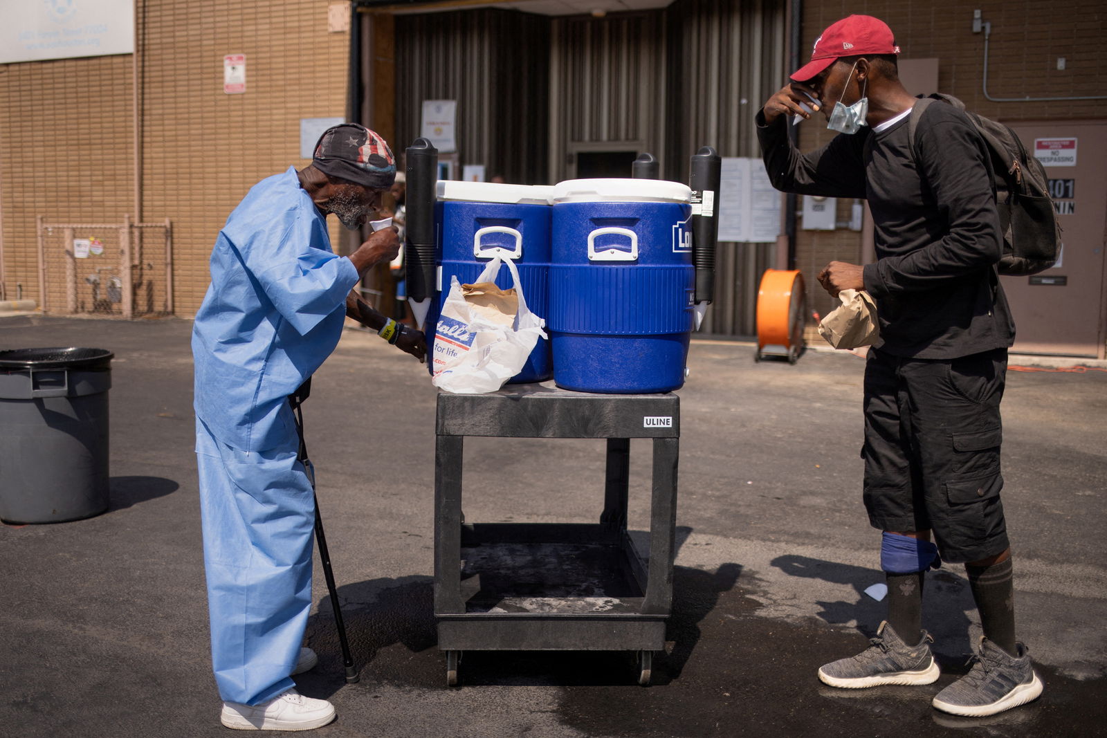 FILE PHOTO: Wayne and Reggie drink water outside the Emergency Aid Coalition during a heat wave in Houston, Texas, U.S., August 25, 2023. REUTERS/Adrees Latif/File Photo