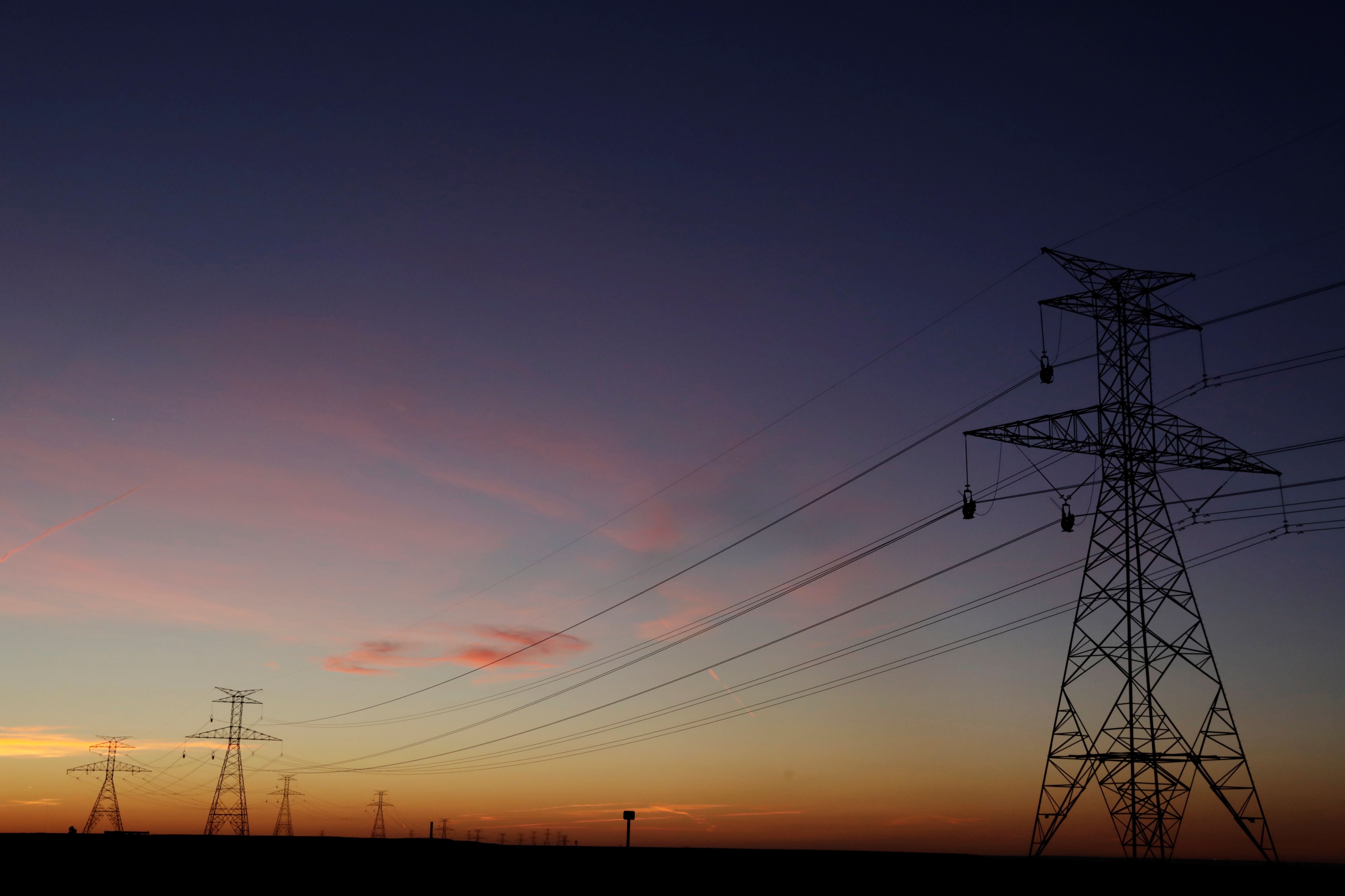 The sun sets behind power lines above the plains north of Amarillo, Texas, U.S., March 14, 2017. REUTERS/Lucas Jackson