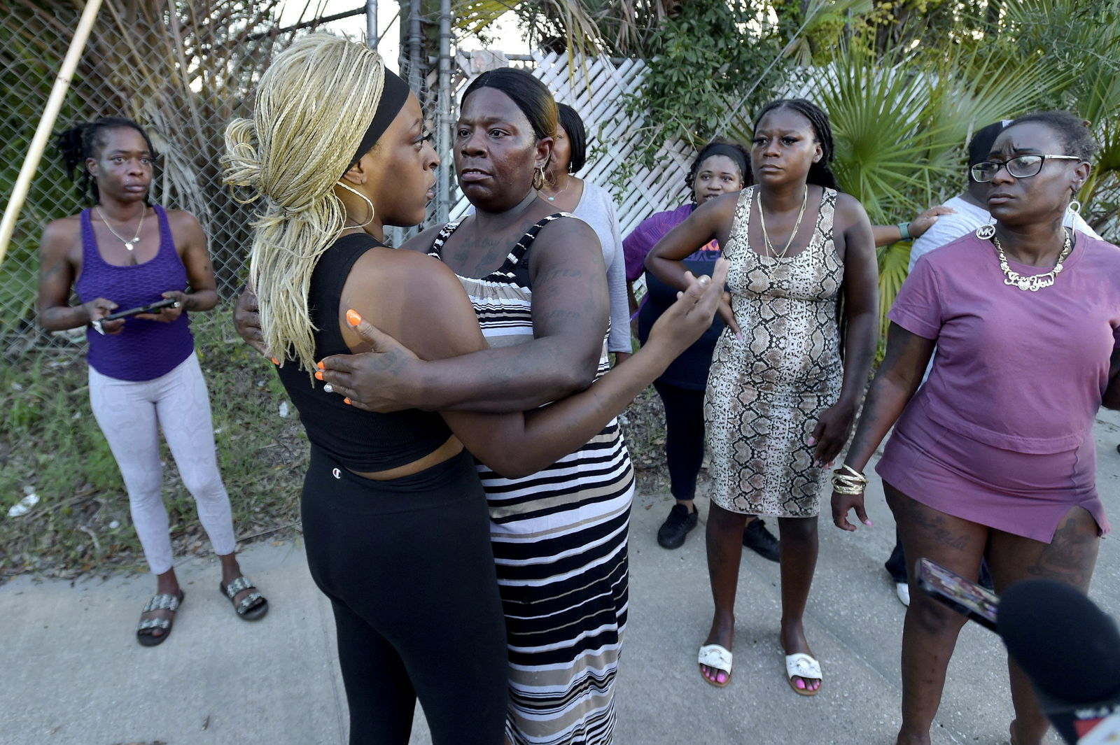 Neighborhood resident Virginia Bradford hugs a woman who came to the police line after going to the hospital to see her child and the child's father who she said were shot at the Dollar General Store, after police said a white man armed with a high-powered rifle and a handgun killed three Black people before shooting himself, in what local law enforcement described as a racially motivated crime in Jacksonville, Florida, U.S. August 26, 2023. Bob Self/USA Today Network via REUTERS.