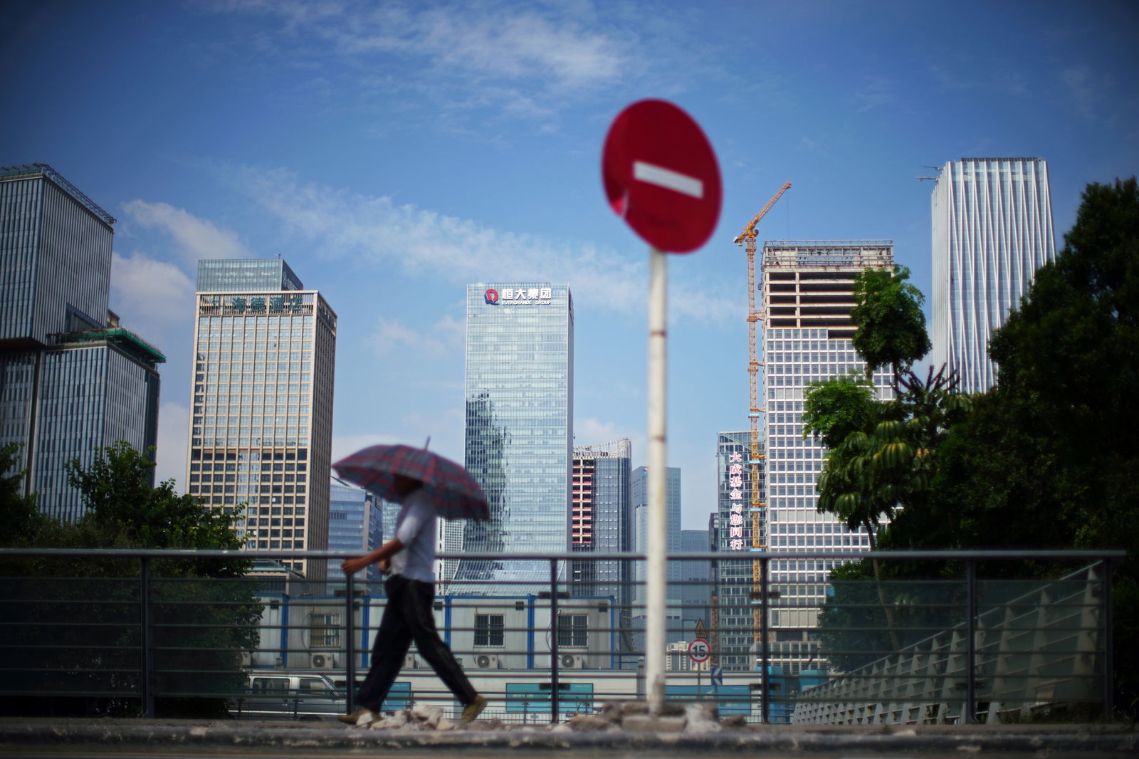 A man walks past a No Entry traffic sign near the headquarters of China Evergrande Group in Shenzhen, Guangdong province, China, Sept. 26, 2021.