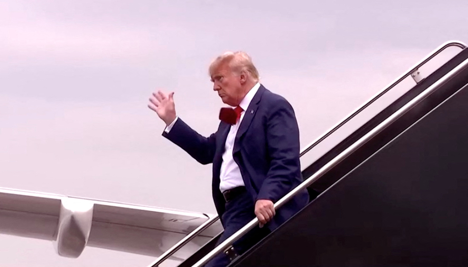 Former U.S. President Donald Trump, who is to appear in a federal court facing federal charges related to attempts to overturn his 2020 election defeat, waves as he arrives in this still image taken from video at Reagan Washington National Airport in nearby Arlington, Virginia, U.S., August 3, 2023. REUTERS/Pool