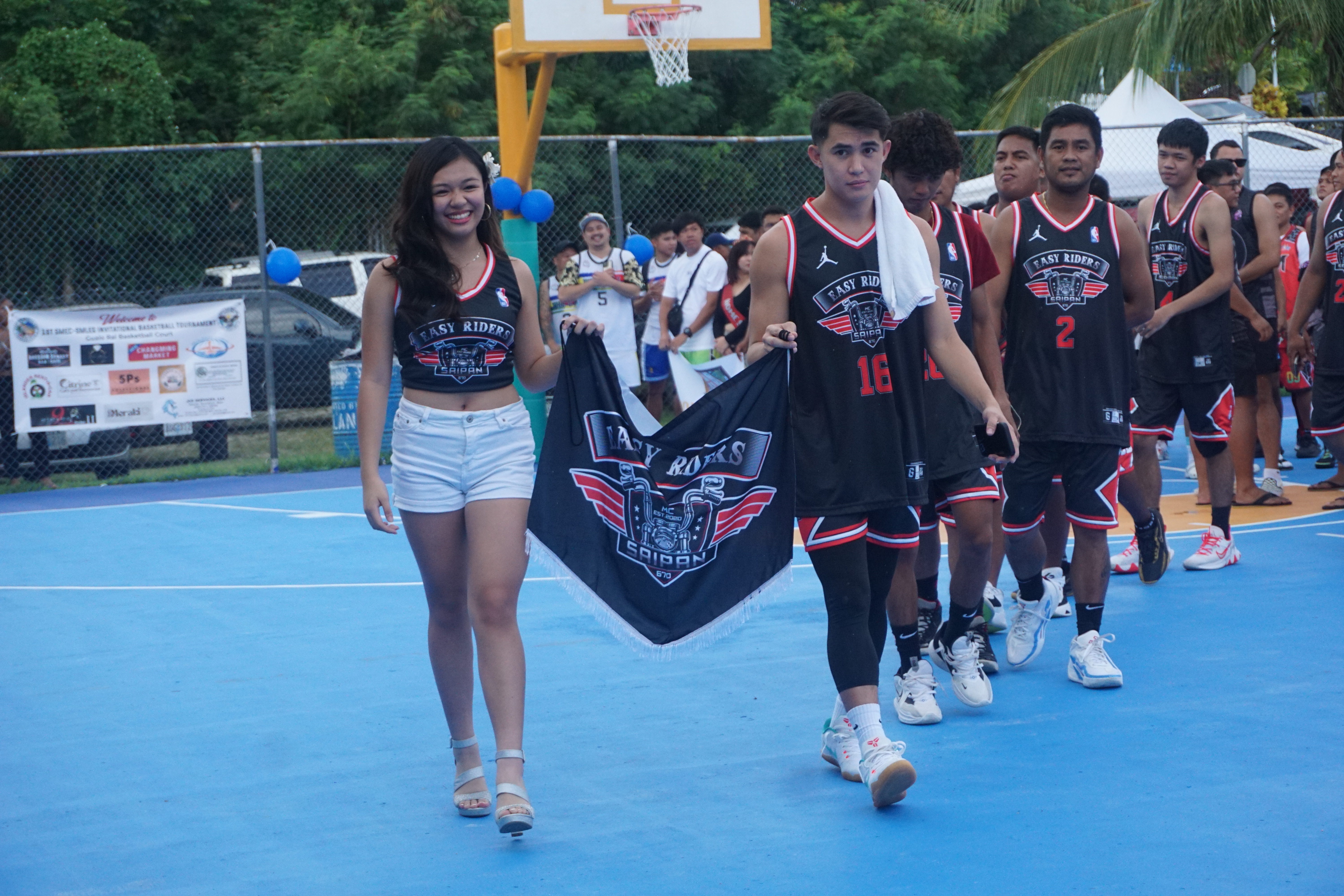 The Easy Riders, along with their muse, make their way through the Gualo Rai basketball court.