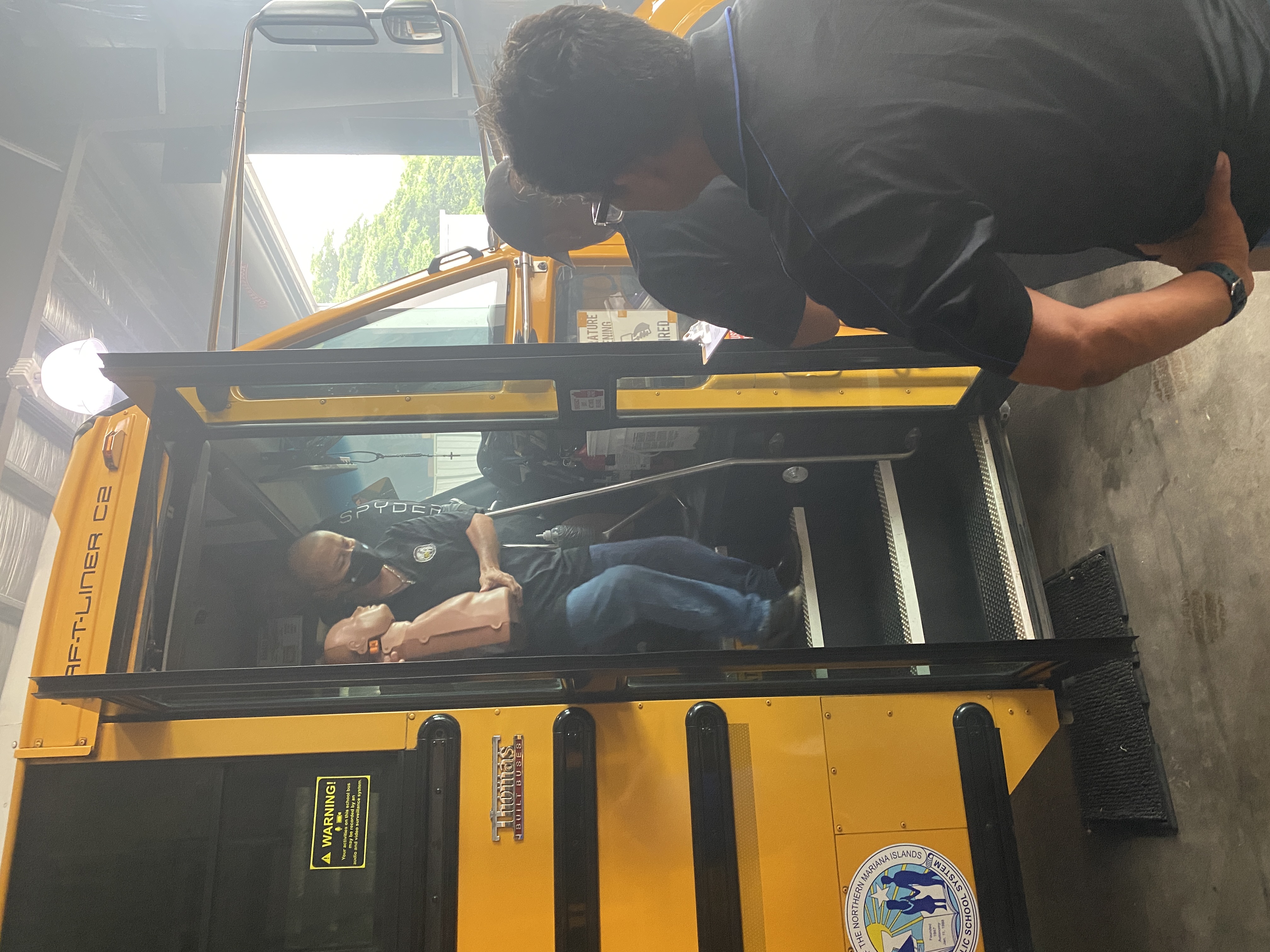 Rudy Cepeda exits a school bus holding one of three mannequins hidden inside. 