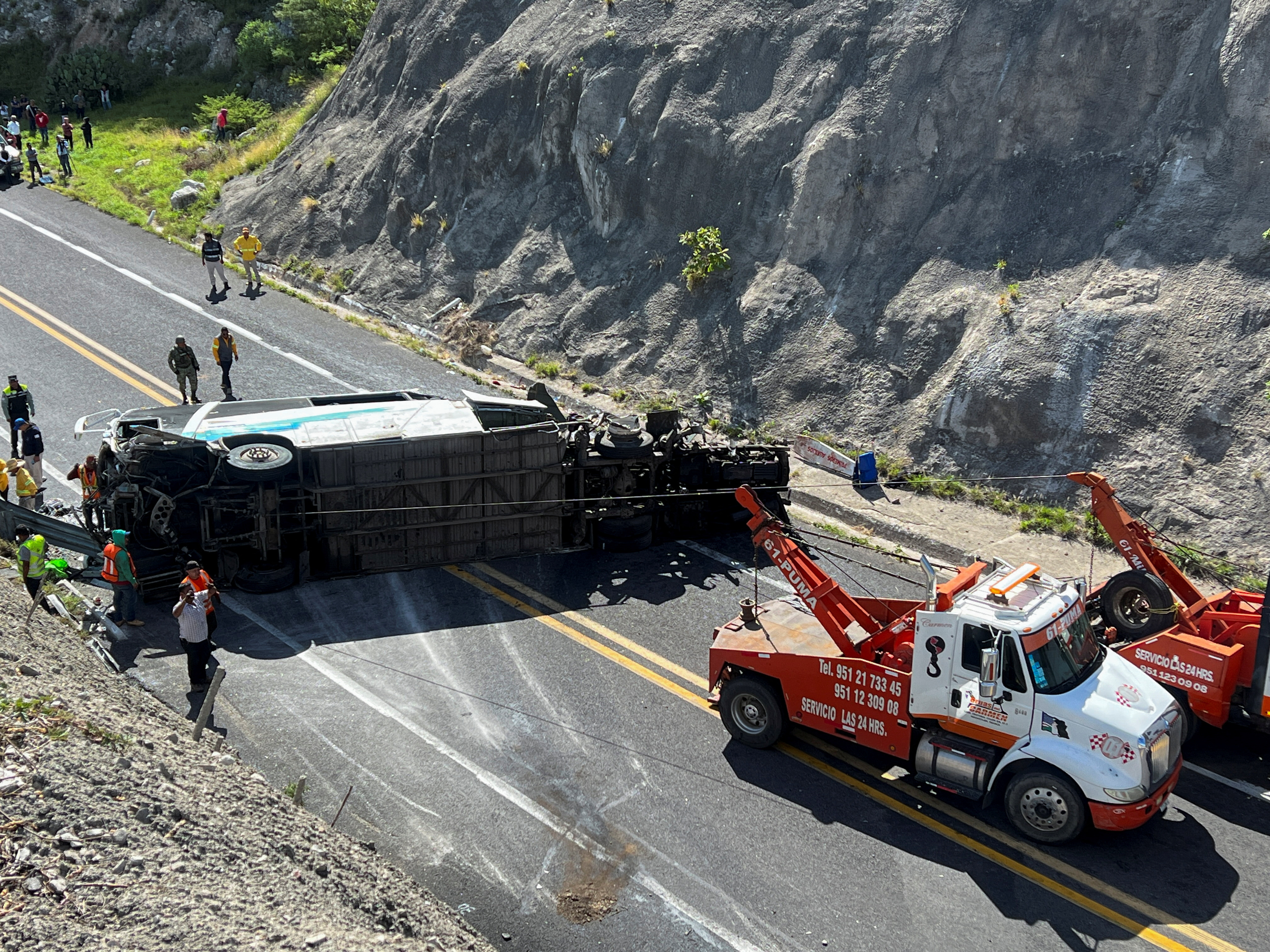Tow trucks and authorities work at the area of a road accident, which left over a dozen migrants dead, in Tepelmeme Villa de Morelos, in Oaxaca state, Mexico August 22, 2023. REUTERS/Jose de Jesus Cortes