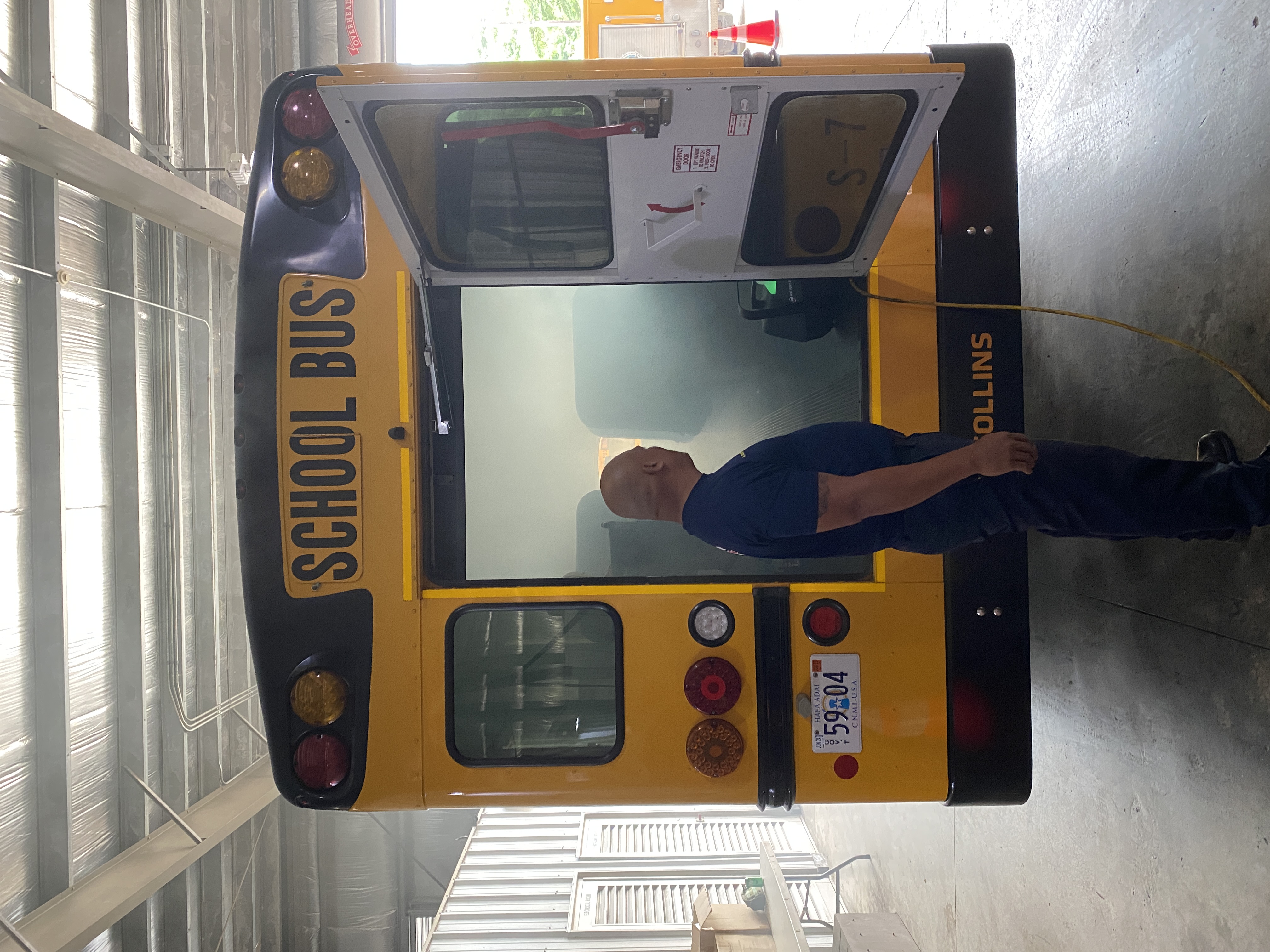 A firefighter uses a smoke ejector to fill a special needs bus with simulated smoke.