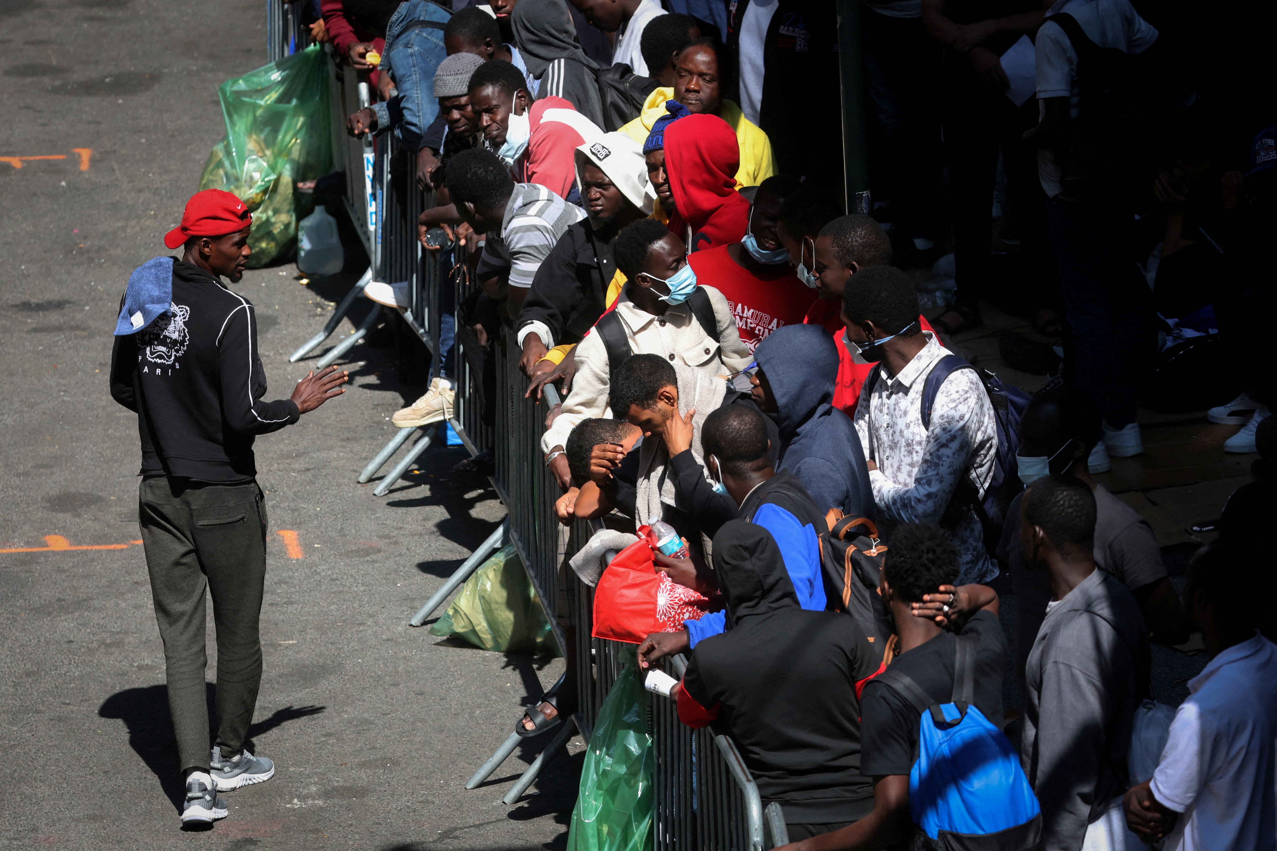 Recently arrived migrants to New York City wait on the sidewalk outside the Roosevelt Hotel in midtown, Manhattan, where a temporary reception center has been established in New York City, New York, U.S., August 1, 2023. REUTERS/Mike Segar/File Photo