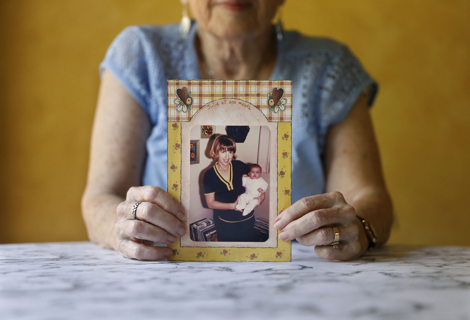 Sherry Hill holds a photograph of herself as a new mom holding her one-month-old daughter in 1970, at home in Clovis, California, on July 26, 2023. (Christina House/Los Angeles Times/TNS)
