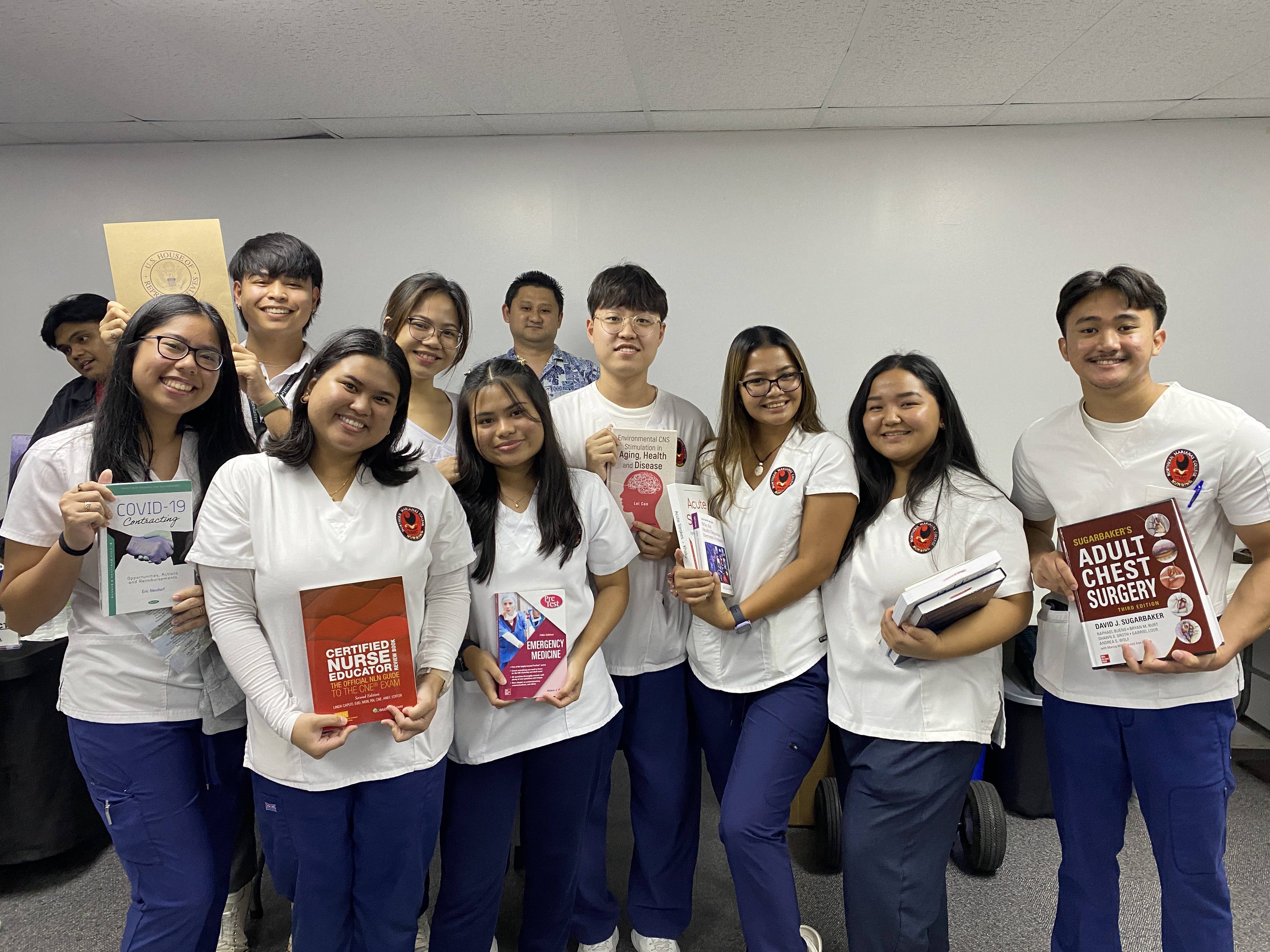 Northern Marianas College nursing students pose with the free books they received from the office of U.S. Congressman Gregorio Kilili Camacho Sablan.