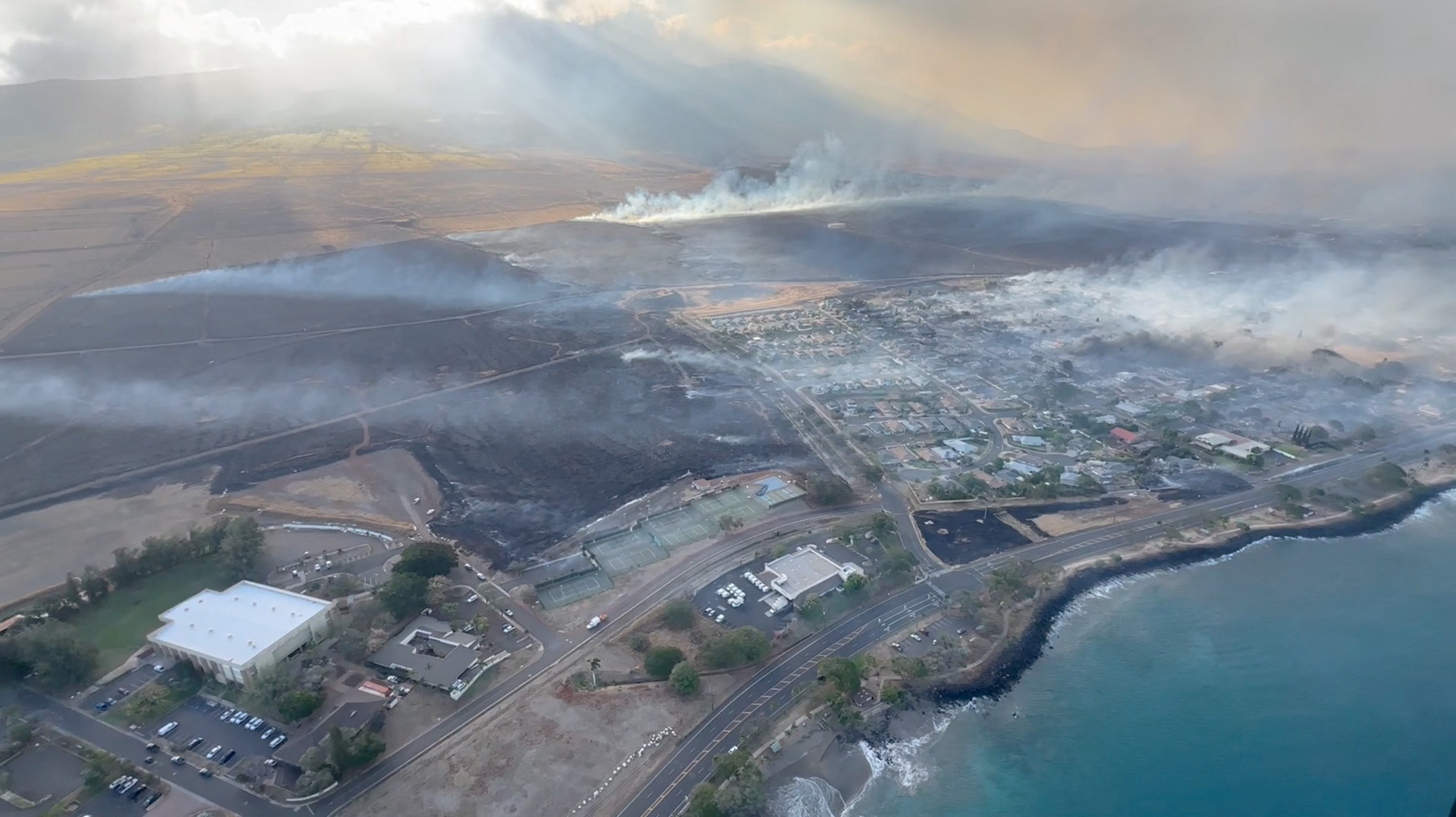 An aerial view as smoke rises from burnt areas amidst wildfires in Maui, Hawaii, U.S., August 9, 2023, in this screenshot taken from a social media video. Vince Carter/via REUTERS