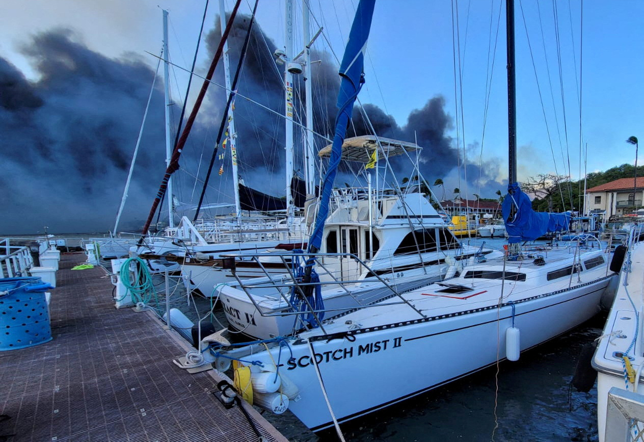 Smoke billows near boats docked at Lahaina as wildfires driven by high winds destroy a large part of the historic town of Lahaina, Hawaii, U.S. August 9, 2023. Dustin Johnson/Handout via REUTERS