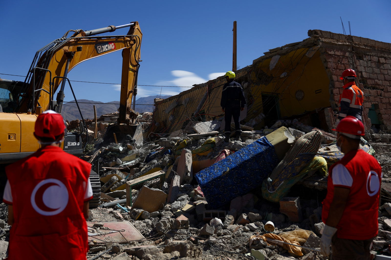 Workers stand among rubble in the aftermath of a deadly earthquake in Talat N'yaaqoub, Morocco, September 11, 2023. 