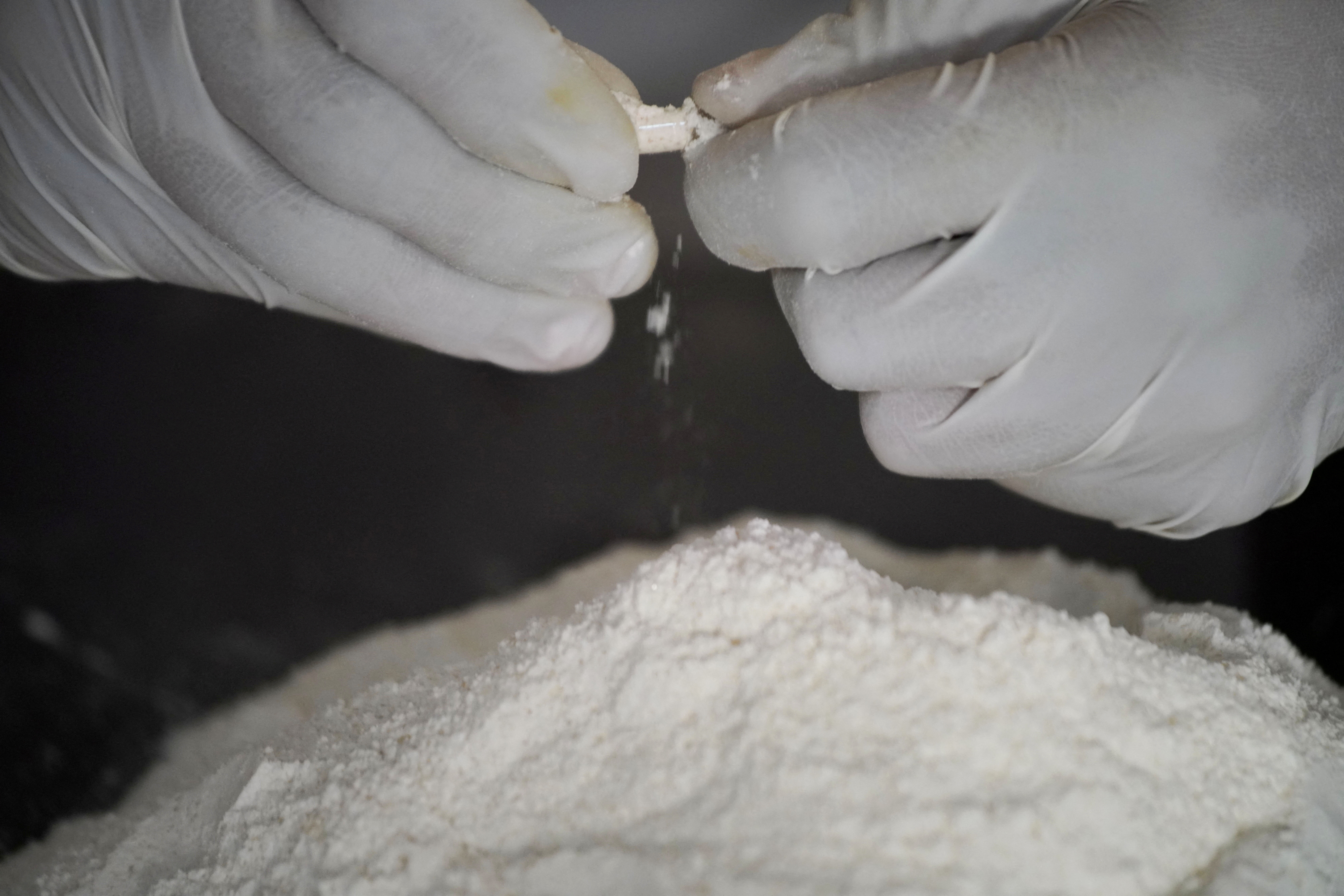 A member of the Sinaloa Cartel prepares capsules with methamphetamine in a safe house in Culiacan, Mexico, April 4, 2022. REUTERS/Alexandre Meneghini/File photo