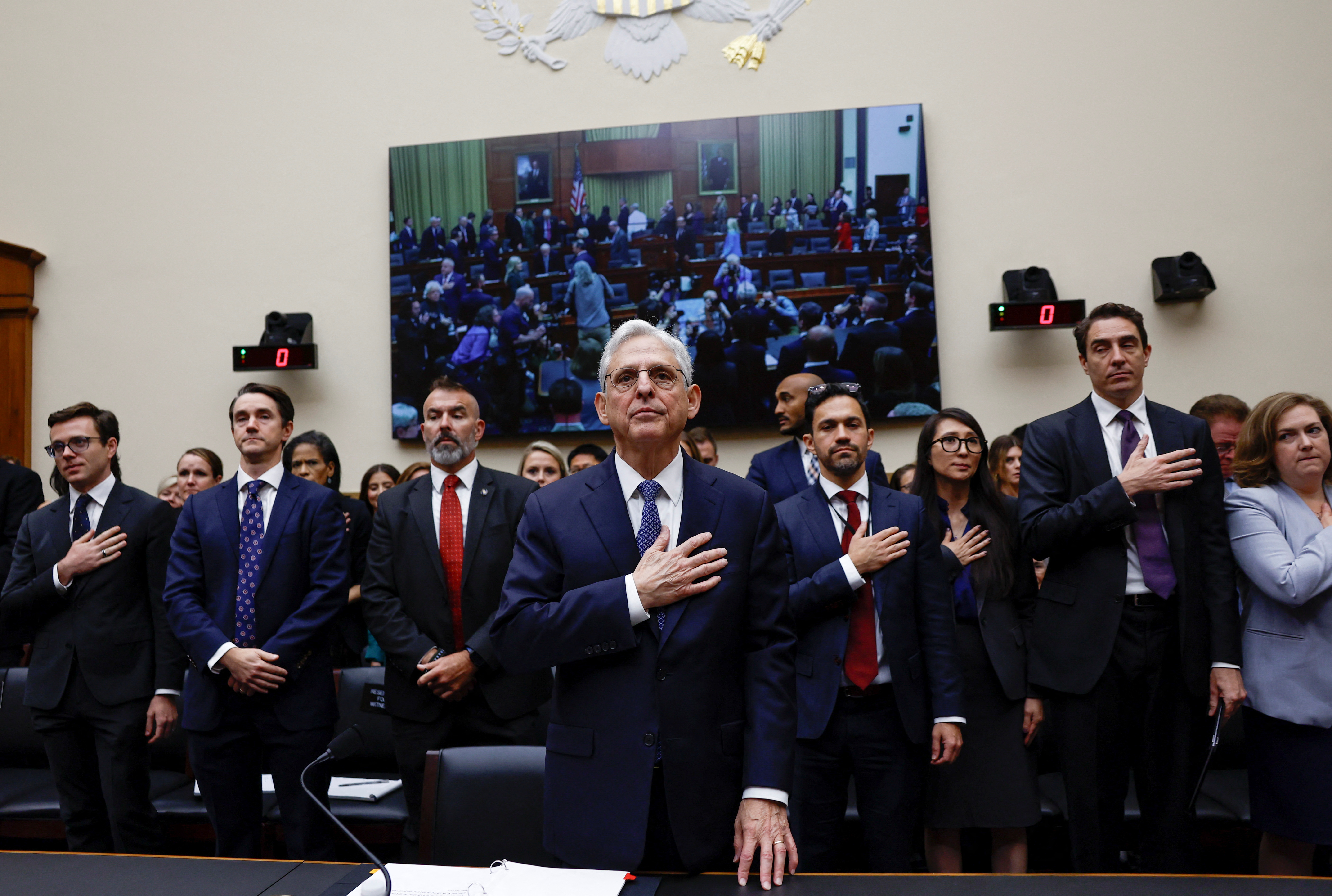 U.S. Attorney General Merrick Garland and attendees in the room hold their hands over their hearts for the U.S. Pledge of Allegiance before the Attorney General begins his testimony in a House Judiciary Committee hearing on the "Oversight of the U.S. Department of Justice," on Capitol Hill in Washington, U.S., September 20, 2023. 