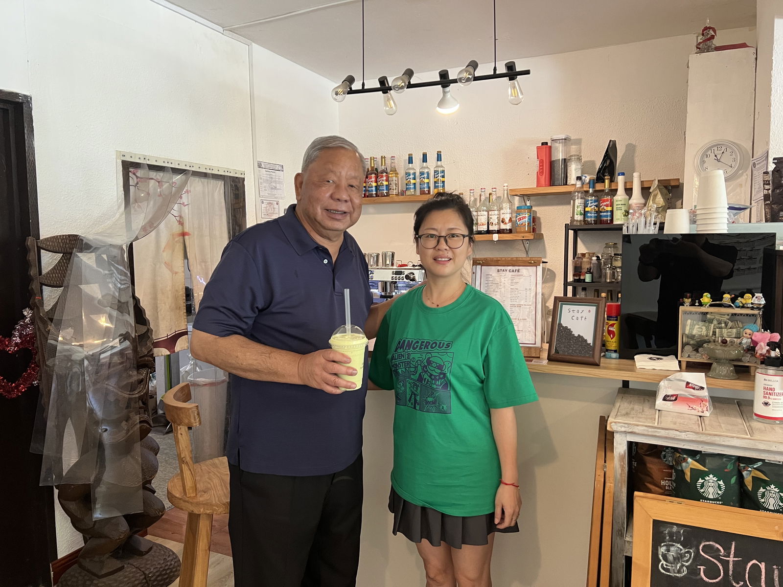 Lt. Gov. David M. Apatang holds his favorite smoothie as he poses with Stay Cafe owner Lily Yu.