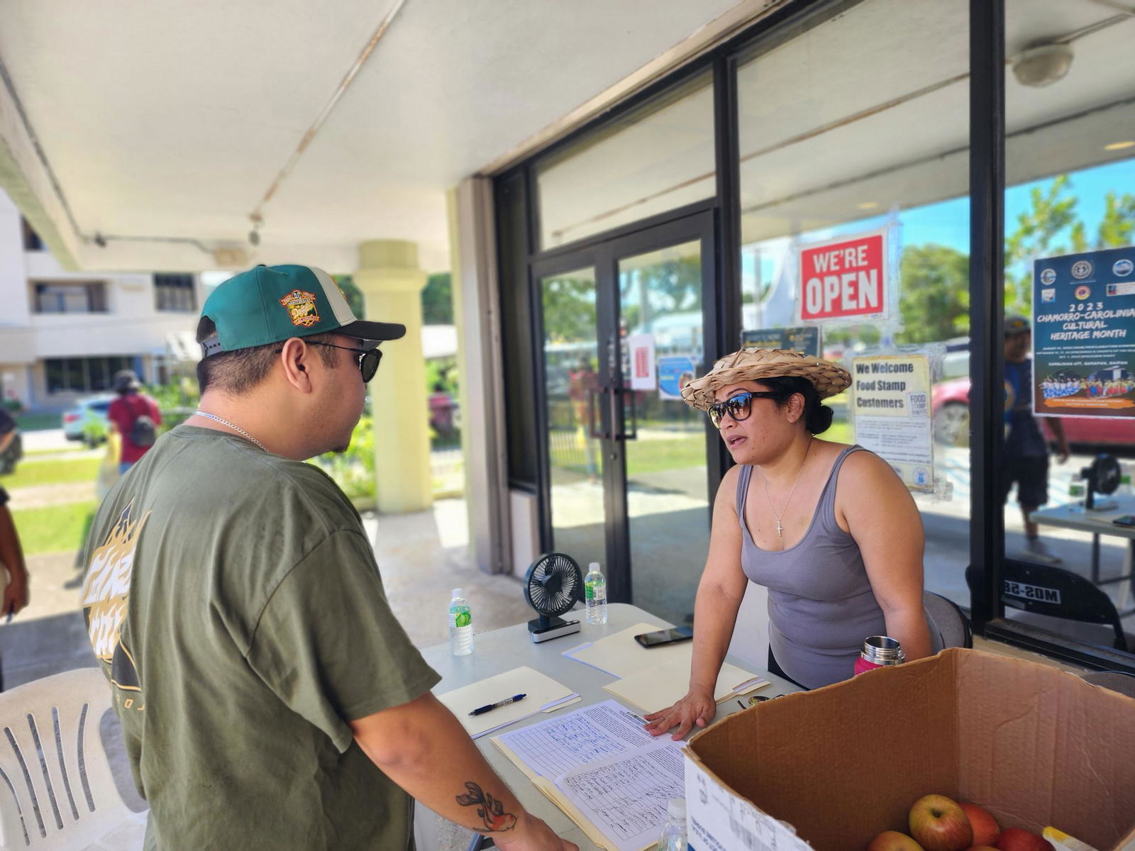 The Saipan Mayor’s Office public information officer, Natasha Tomokane, talks to a resident regarding a signature drive for the removal of Department of Public Lands Secretary Teresita Santos at the Garapan Public Market on Saturday.