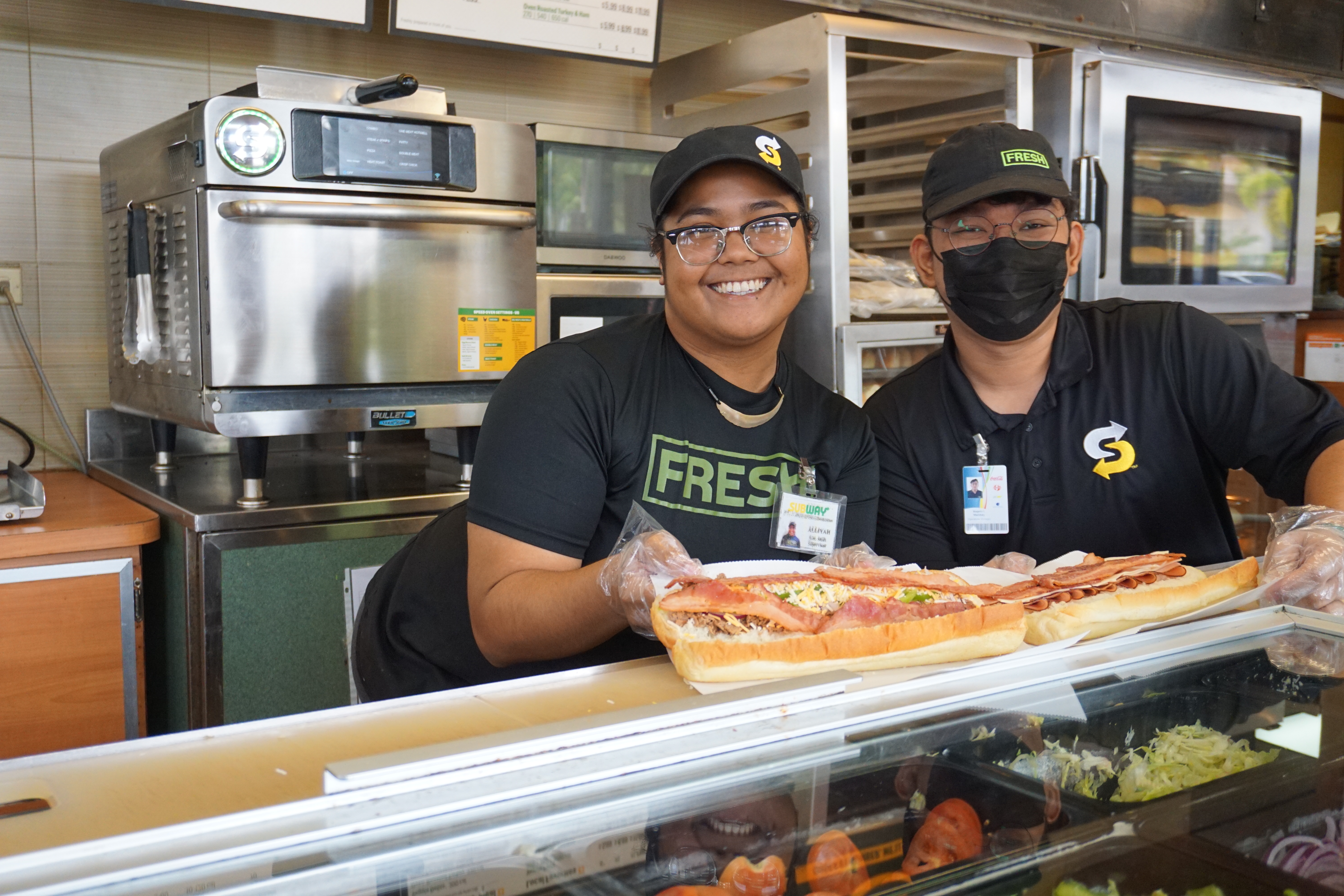 Supervisor Alliyah Ulechong, left, and Angelo Manibay, operations manager at Subway Gualo Rai, prepare a #19 Pickleball Club and #3 The Monster.