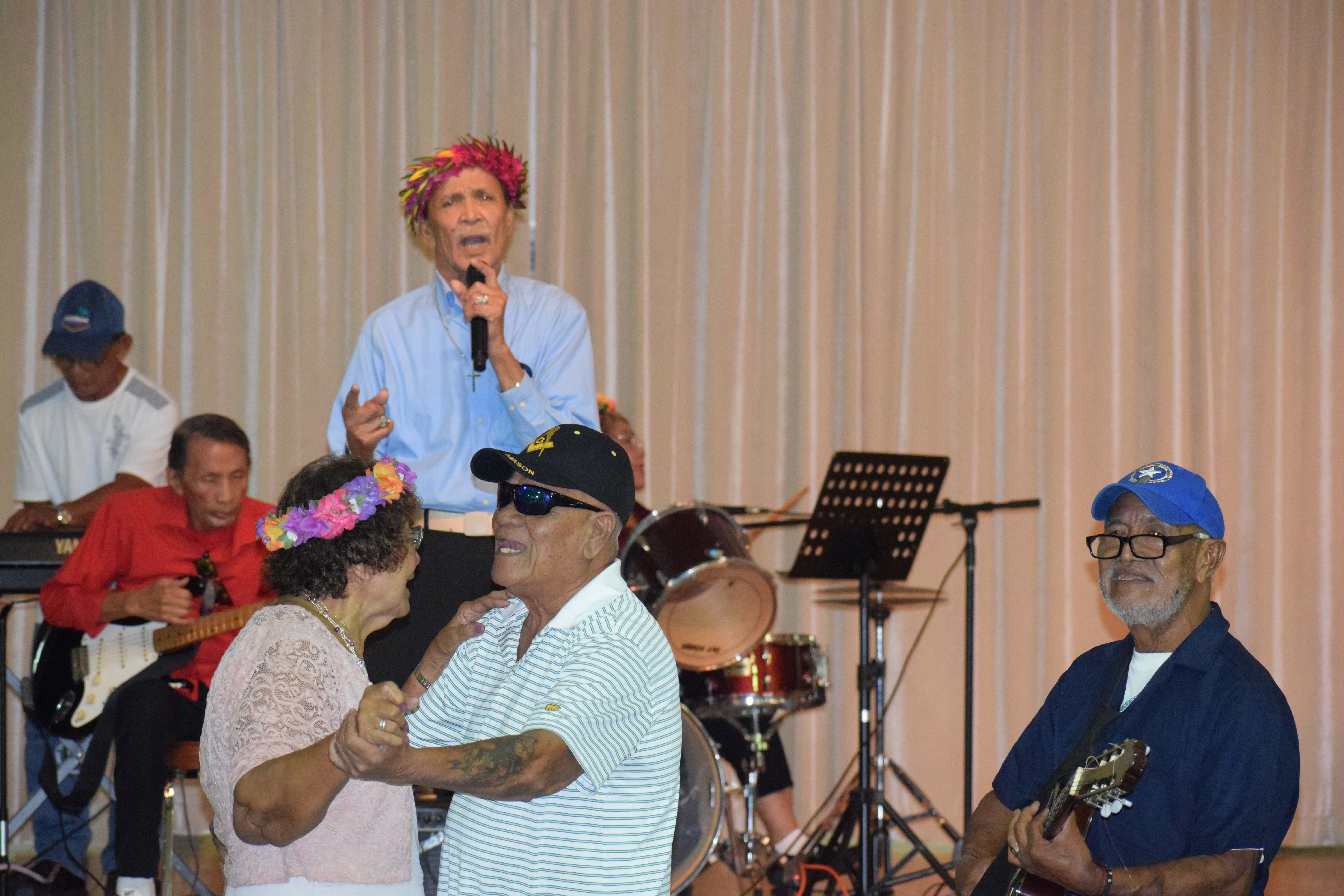 Vicente S. Basa sings, Jess Pangelinan and Juan Agustin play the guitar while a couple dance.