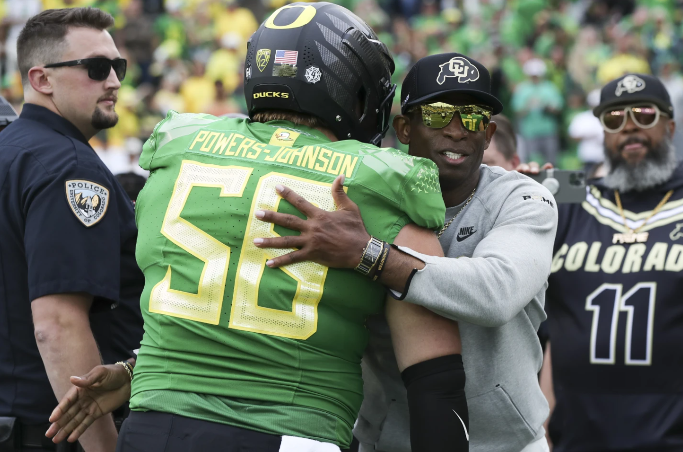 Colorado head coach Deion Sanders hugs Oregon offensive lineman Jackson Powers-Johnson following an NCAA college football game Saturday, Sept. 23, 2023 in Eugene Ore. Oregon won, 42-6.