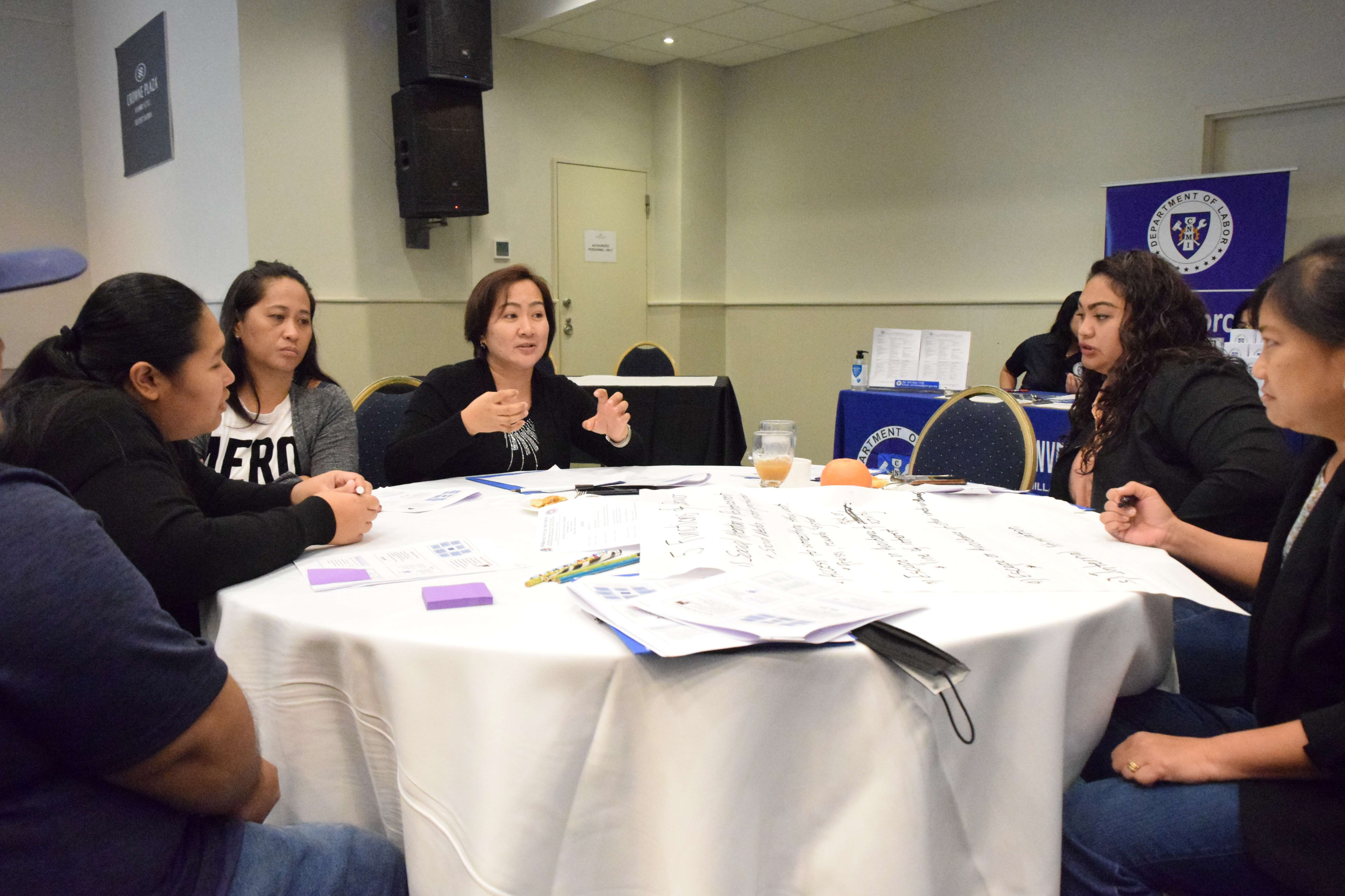 An educator, center, gestures during a  group discussion.