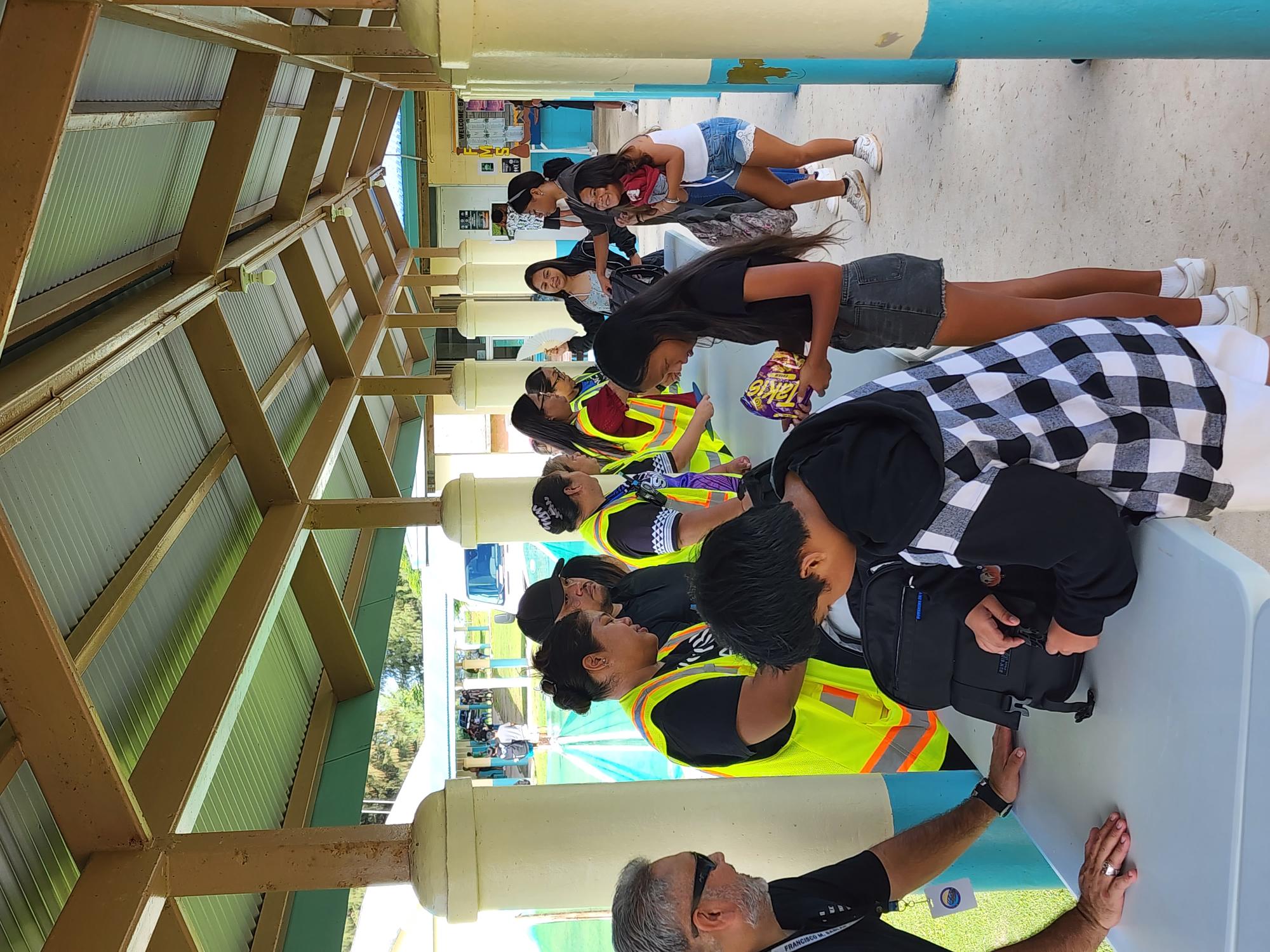 School staffers and police officers conduct a security screening of  students and visitors at Francisco M. Sablan Middle school on Thursday morning.