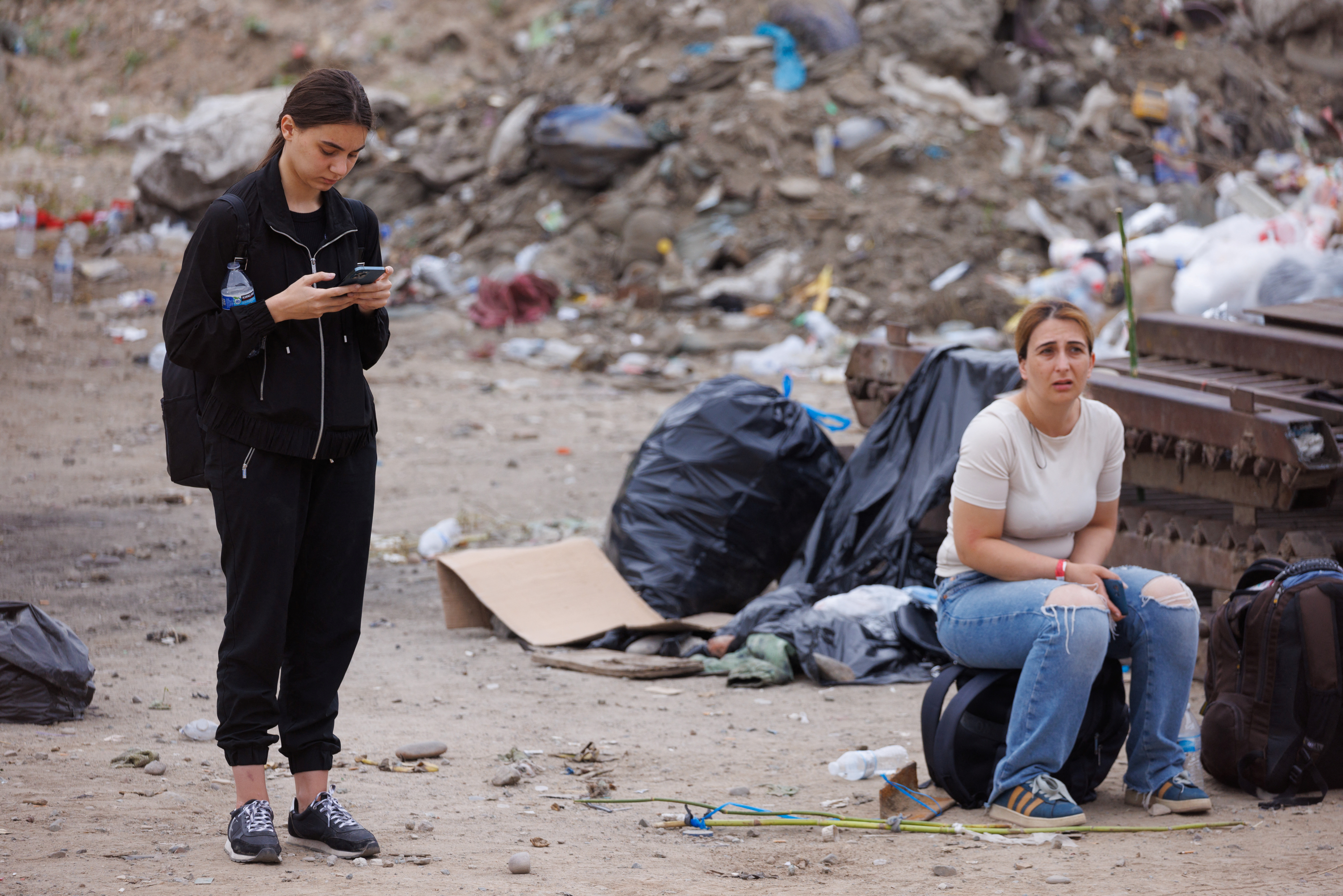 Migrants from Georgia await processing by U.S immigration as they wait between the primary and secondary border fences between Mexico and the United States in San Diego, U.S., September 14, 2023. 