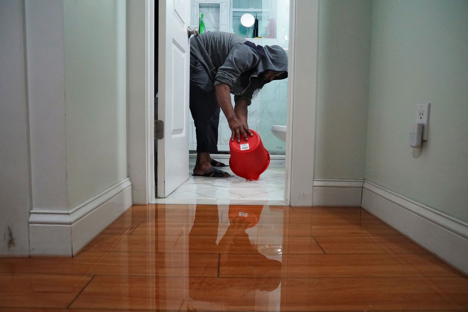 Mohammed Doha, 52, a construction worker, scoops contaminated water out of his flooded first-floor home in the Hole, one of the lowest neighborhoods in the Brooklyn borough of New York City, U.S., September 29, 2023. 