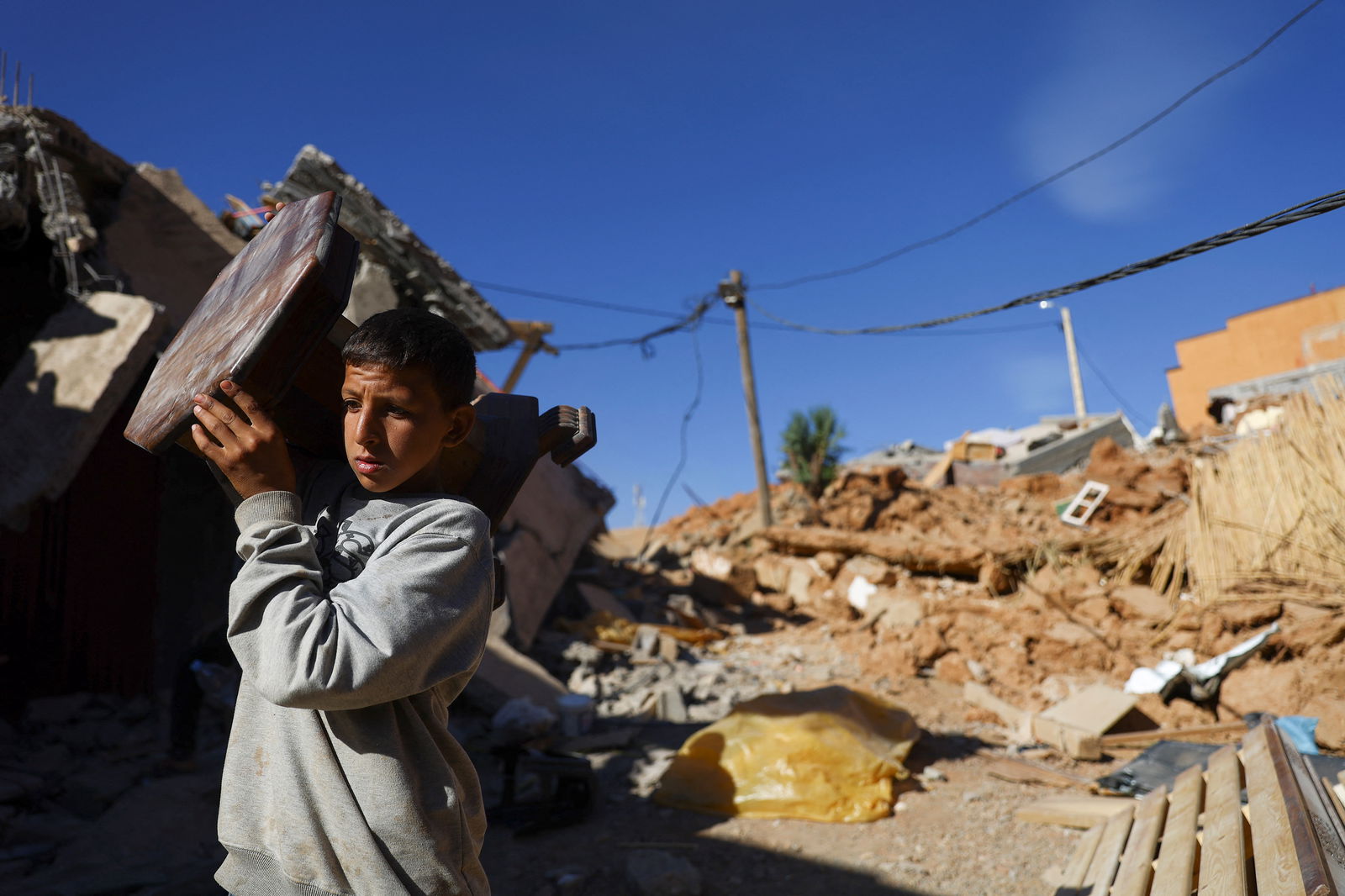A person carries an item of furniture, in the aftermath of a deadly earthquake, in a hamlet on the outskirts of Talaat N'Yaaqoub, Morocco, September 11, 2023. REUTERS/Hannah McKay
