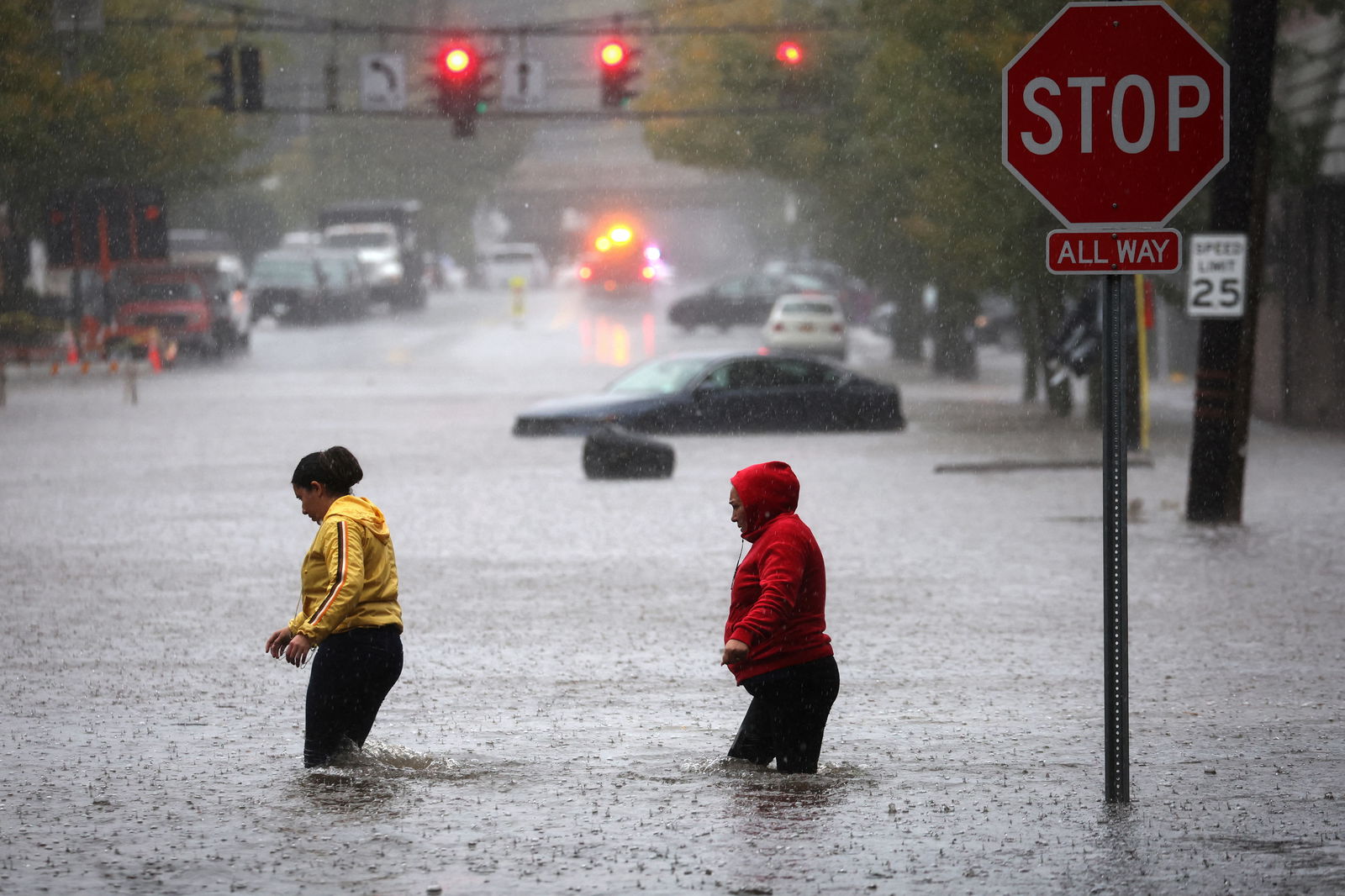 Residents walk through floodwaters during a heavy rain storm in the New York City suburb of Mamaroneck in Westchester County, New York, U.S., September 29, 2023. 