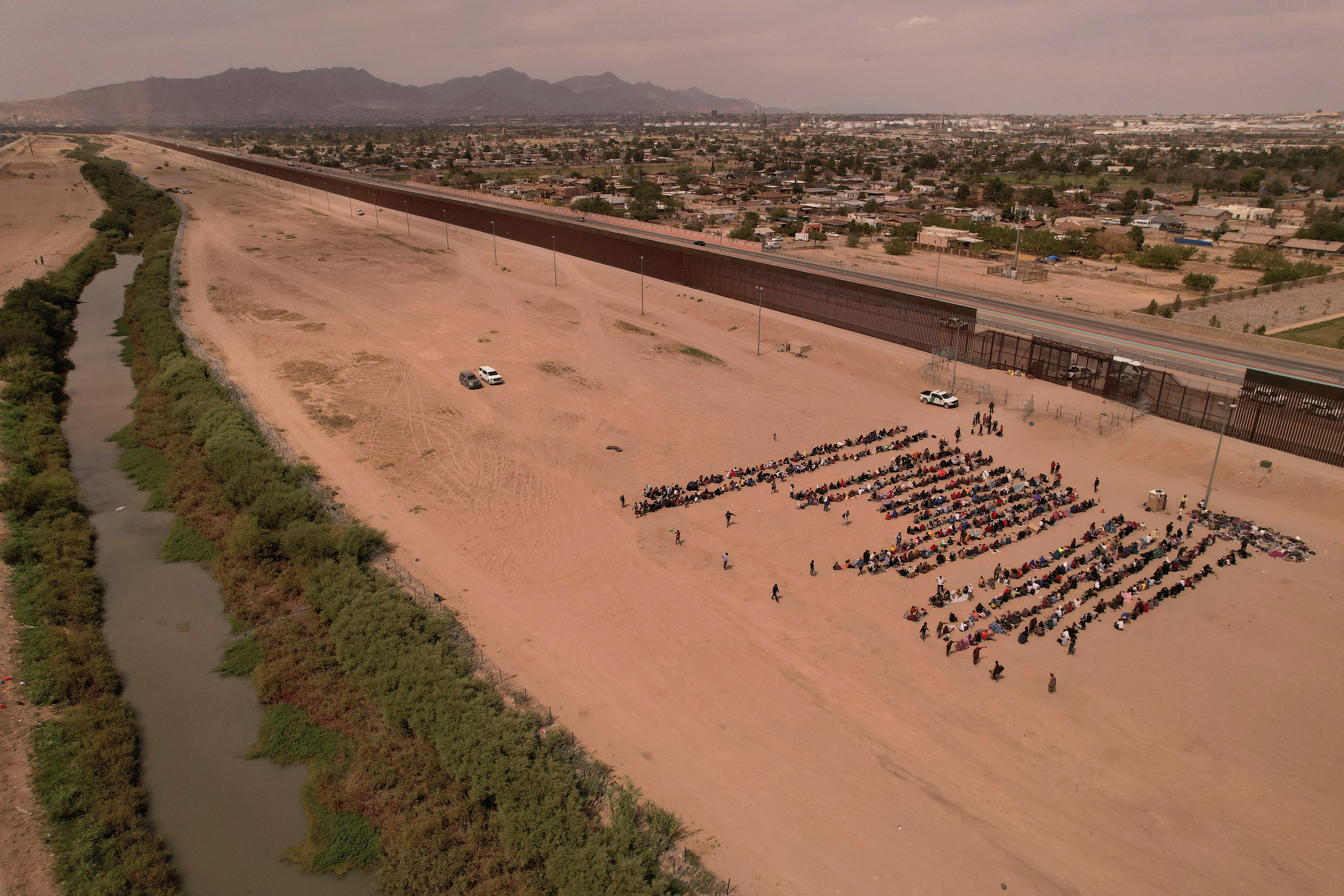 Migrants, mostly from Venezuela, sit near the border wall after crossing the Rio Bravo river with the intention of turning themselves in to the U.S. Border Patrol agents, as seen from Ciudad Juarez, Mexico September 21, 2023. 