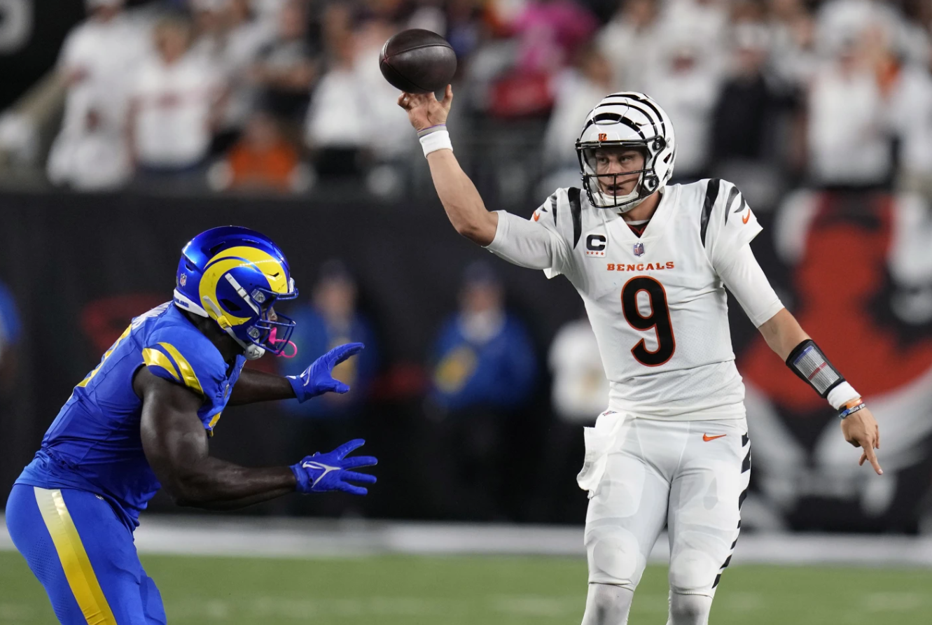 Cincinnati Bengals quarterback Joe Burrow, right, throws over Los Angeles Rams outside linebacker Byron Young during the second half of an NFL football game Monday, Sept. 25, 2023, in Cincinnati.