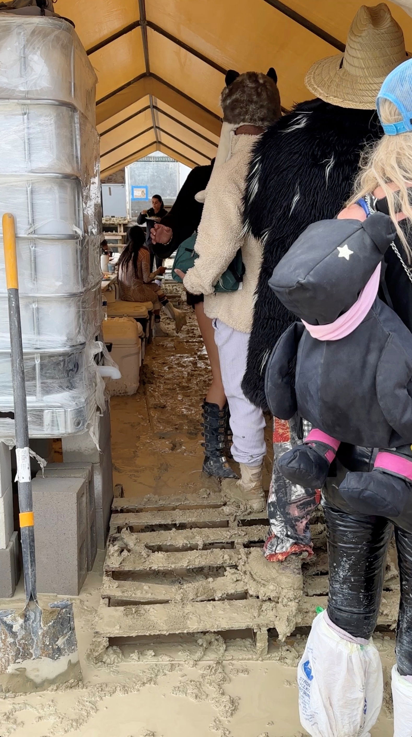 People use plastic bags to cover their shoes as others are seen with their boots covered in mud at the site of the Burning Man festival in Black Rock, Nevada, U.S., September 2, 2023, in this screen grab obtained from a social media video. Paul Reder/via REUTERS