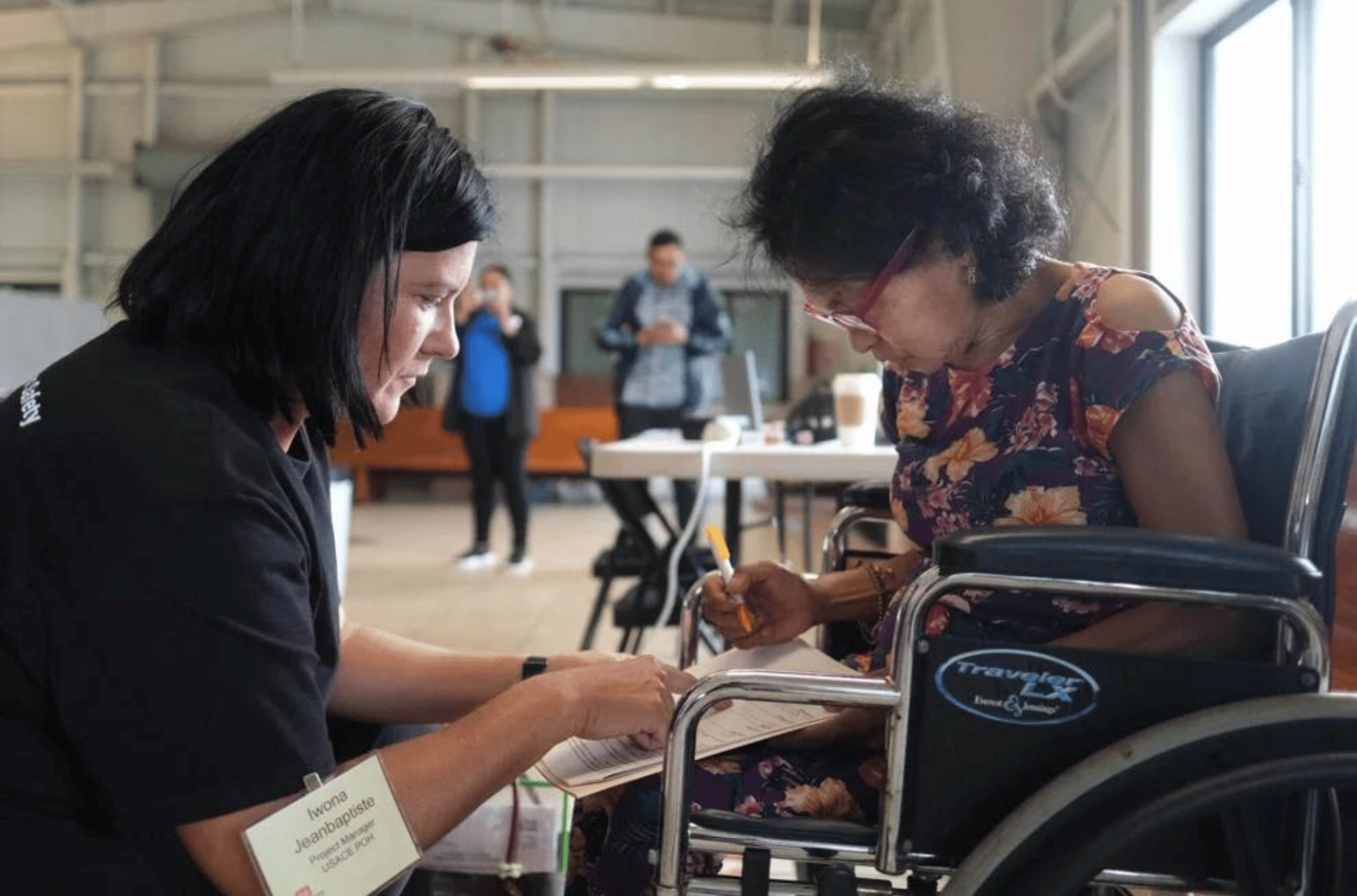 Iwona Jeanbaptiste, left, project manager for the Army Corps of Engineers Honolulu district, assists Yigo resident Rebecca Oamil with a document during a presentation on an ongoing project to remove bombs and other explosives from a former military site at the St. Lourdes Church Social Hall in Yigo Friday morning.