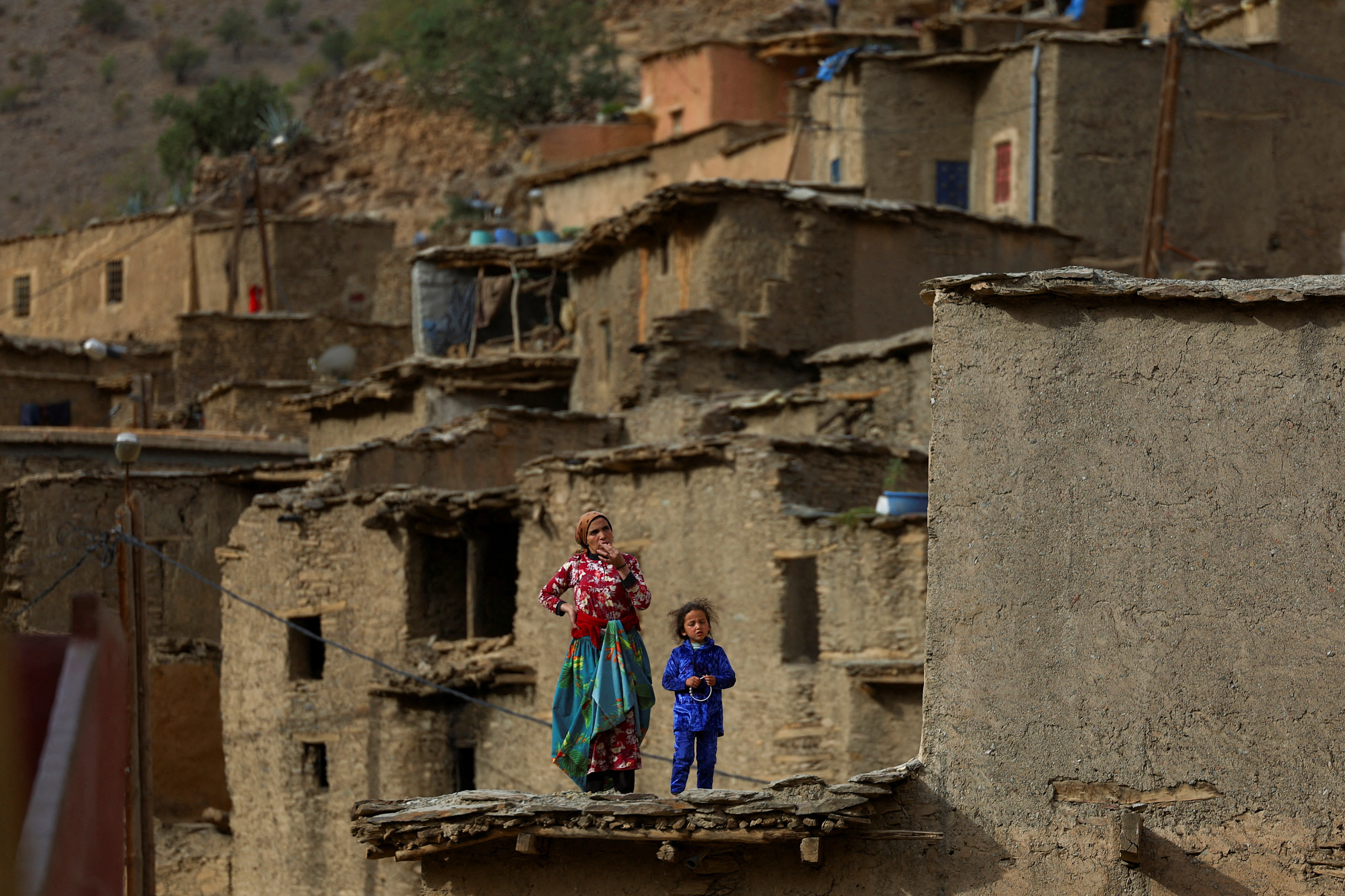 People affected by a deadly earthquake stand on a house, in the rural village of Azermoun, Morocco September 14, 2023. 