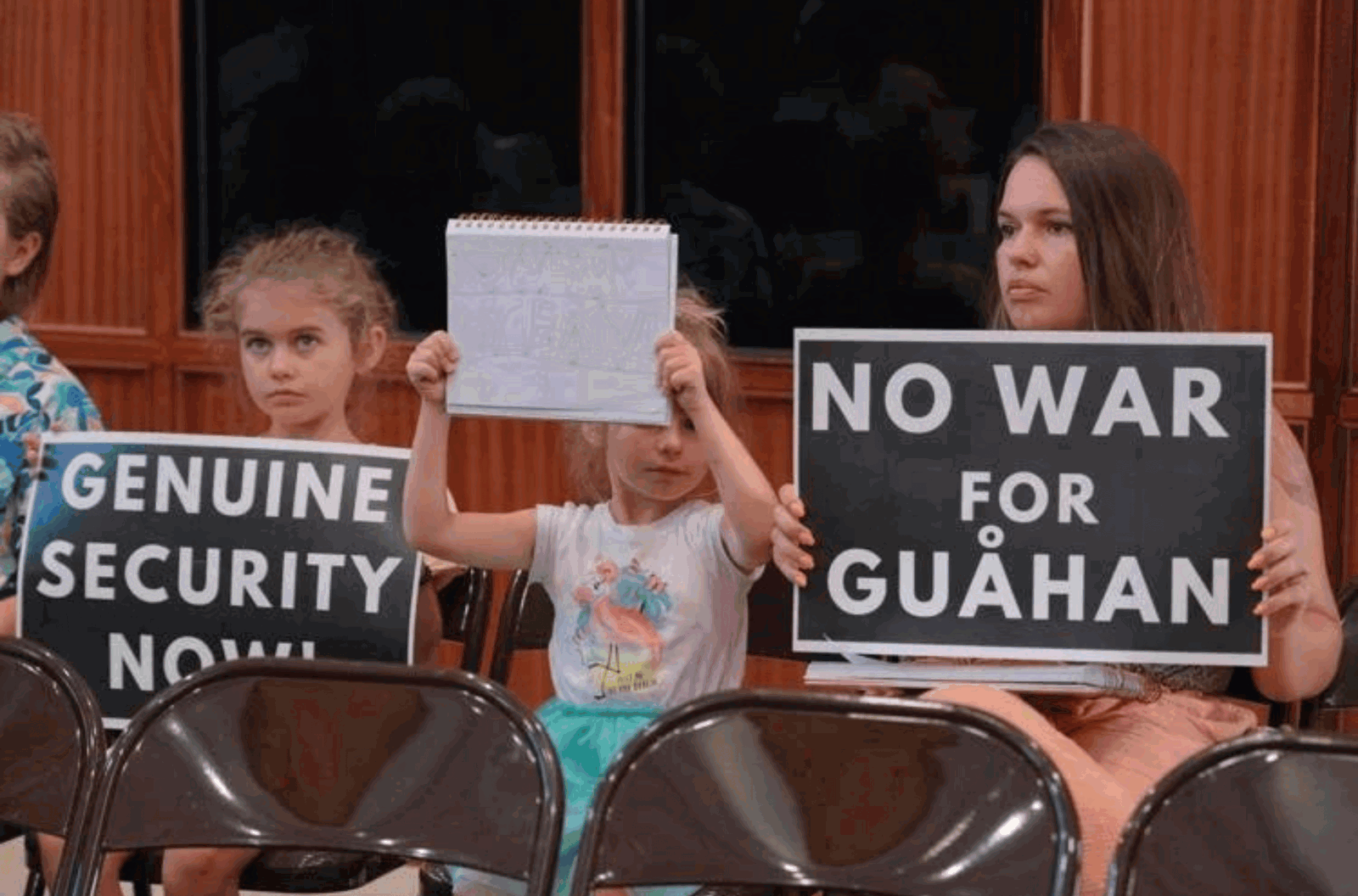 Residents hold signs against the production and use of nuclear energy on Guam during a public hearing Tuesday, Sept. 5, 2023, at the Guam Congress Building in Hagåtña.