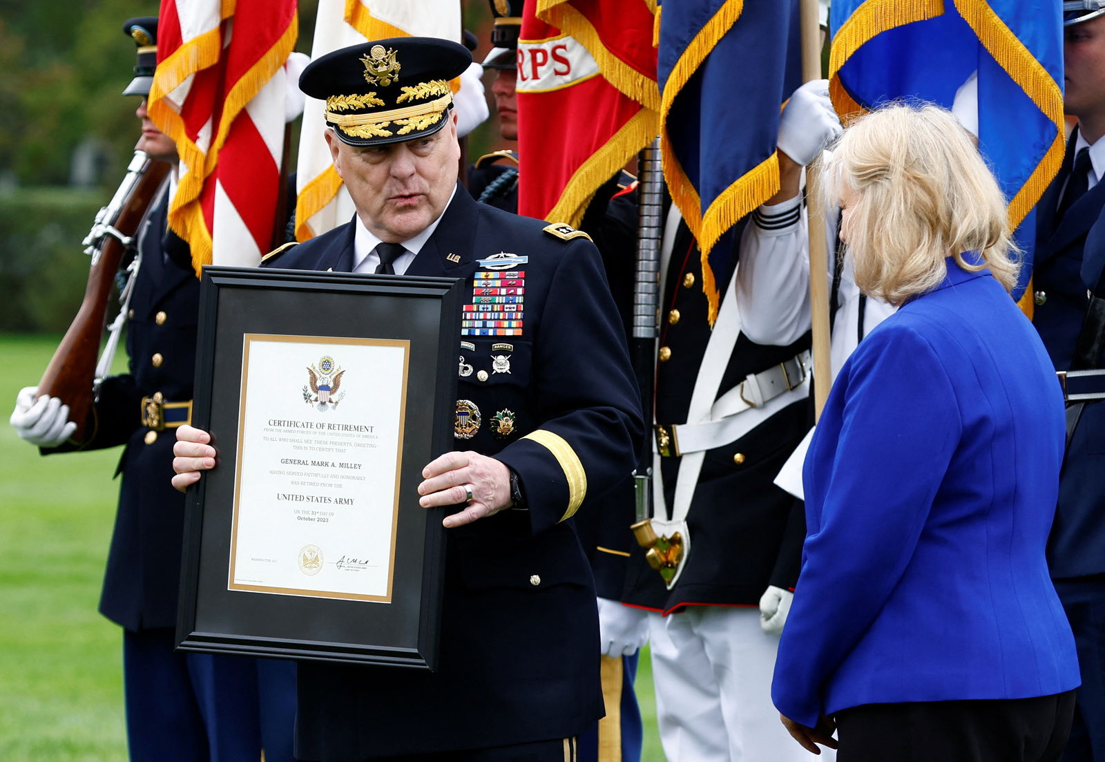 20th Chairman of the Joint Chiefs of Staff General Mark A. Milley holds a certificate of retirement, as stands next to his wife Hollyanne Milley, on the day of the Armed Forces Farewell Tribute in honor of General Milley and an Armed Forces Hail in honor of General Brown, at Summerall Field at Joint Base Myer-Henderson Hall, Arlington, Virginia, U.S., September 29, 2023. 