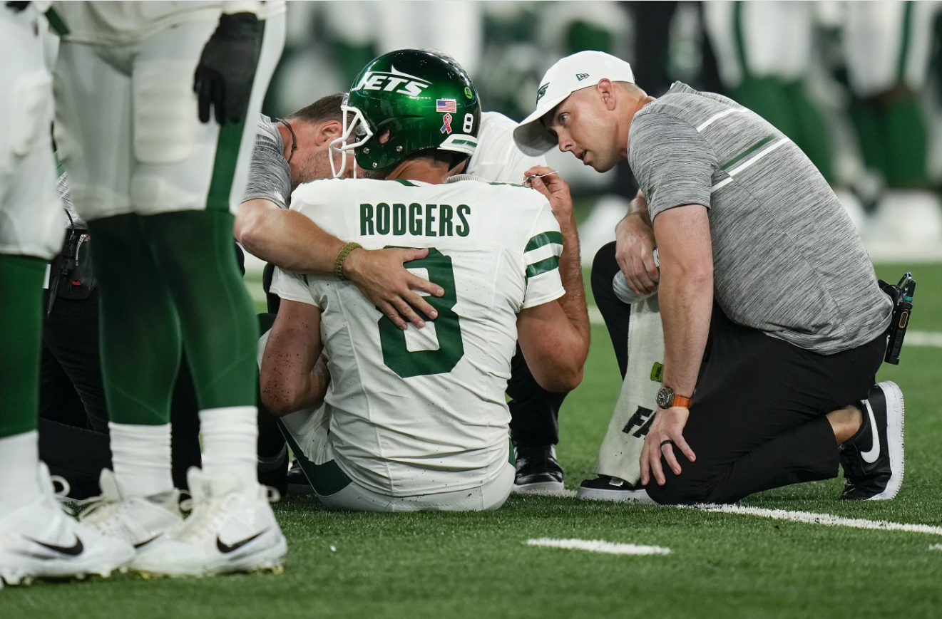 New York Jets quarterback Aaron Rodgers (8) is tended to on the field during the first quarter of an NFL football game against the Buffalo Bills, Monday, Sept. 11, 2023, in East Rutherford, N.J.
