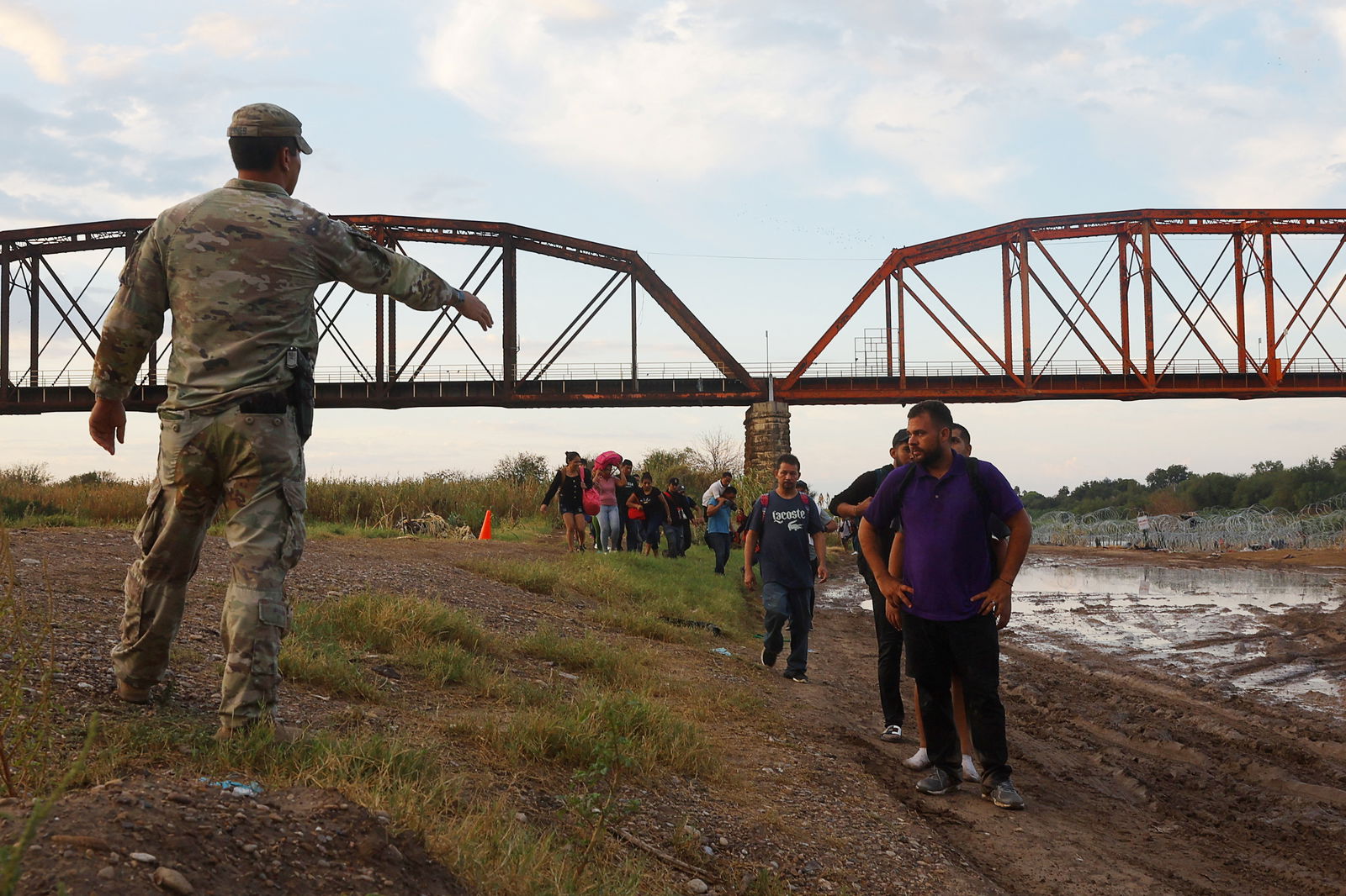 Migrants from Venezuela are directed by a member of the National Guard as they arrive and surrender to authorities in Eagle Pass, Texas, U.S., September 26, 2023. 
