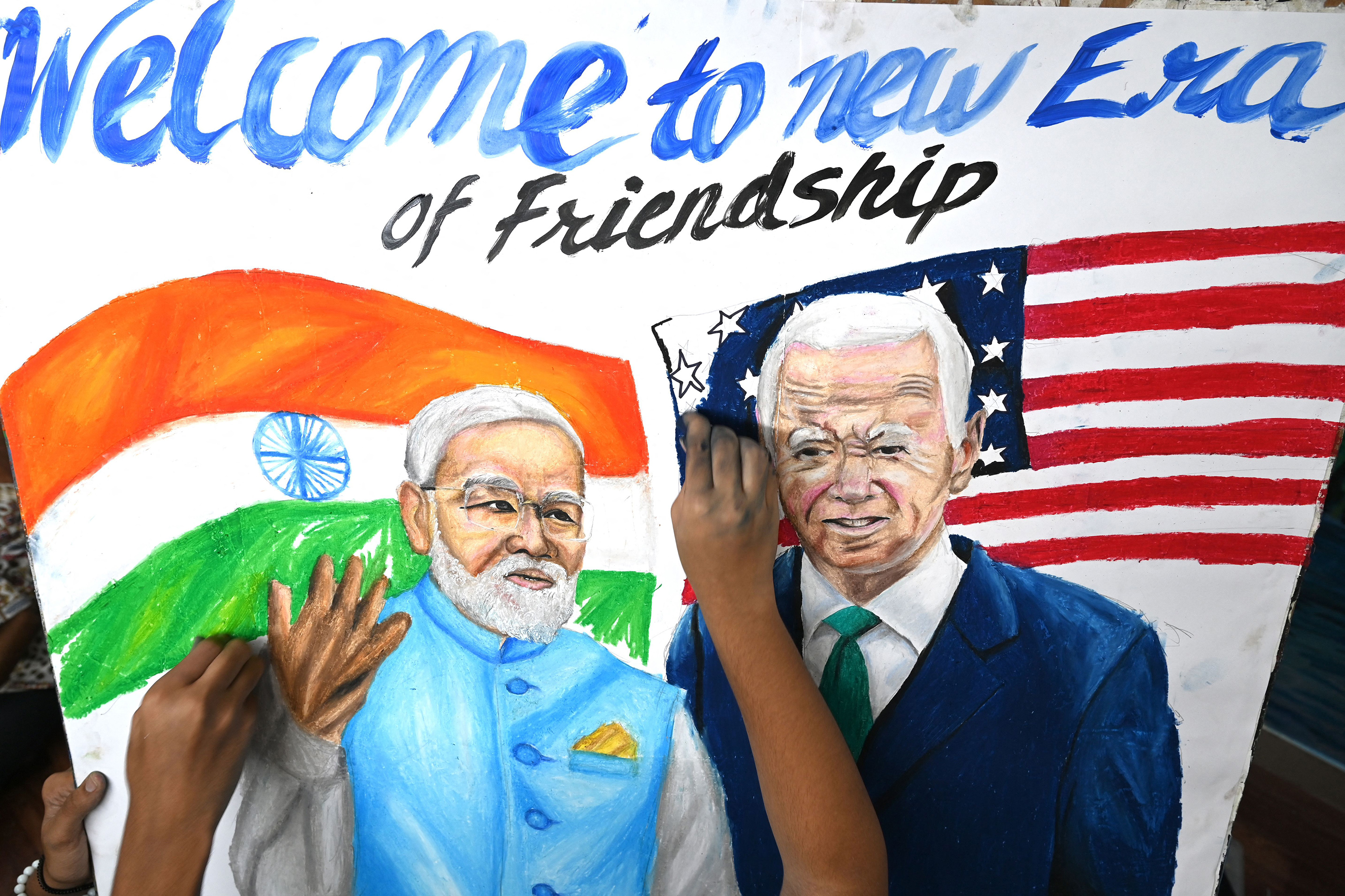 Students give final touches to a painting of India's Prime Minister Narendra Modi and President Joe Biden, at an art school in Mumbai on Sept. 7, 2023, ahead of the two-day G20 summit in New Delhi. (Indranil Mukherjee/AFP/Getty Images/TNS)