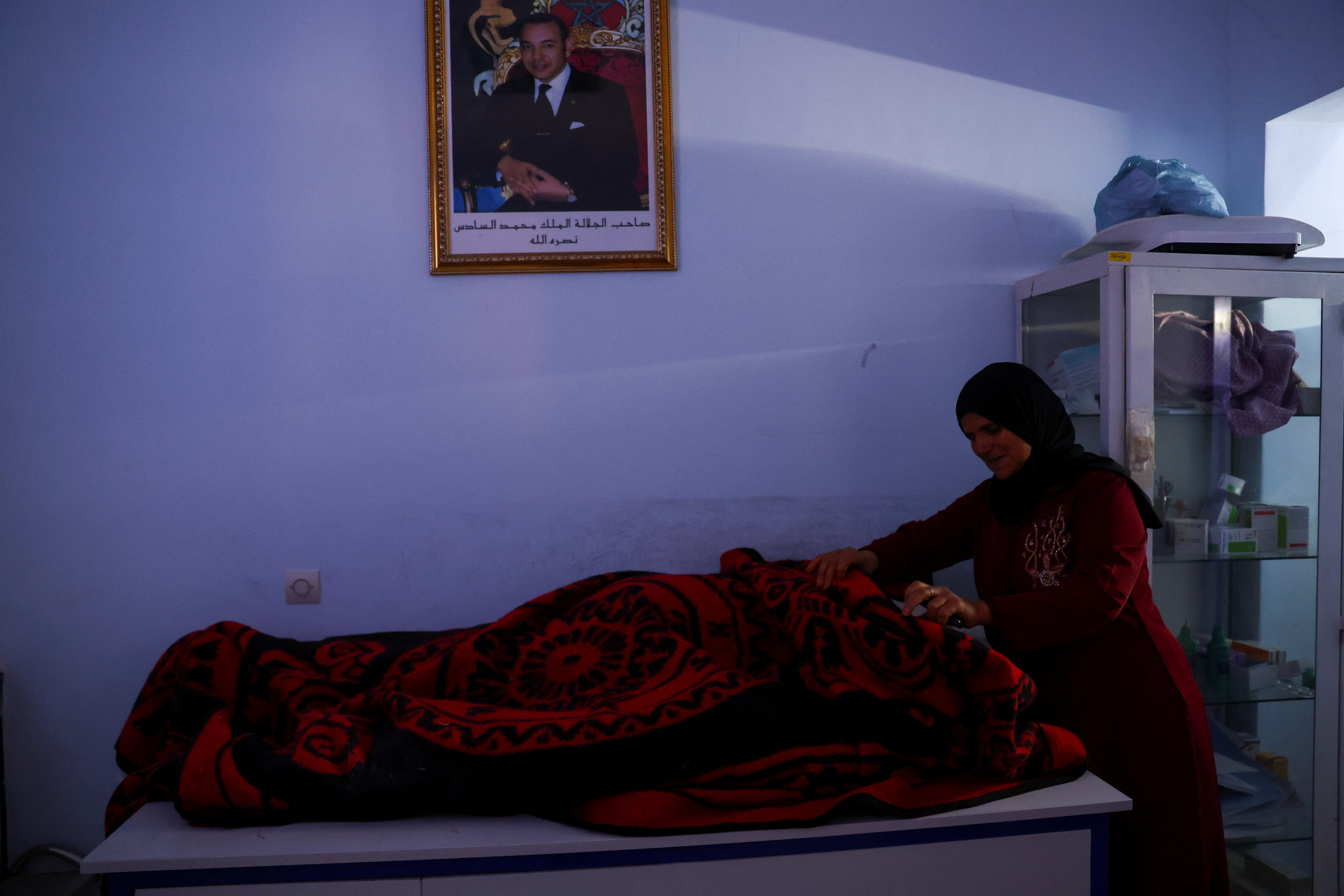 A woman reacts next to the body of a victim of the deadly earthquake, at a health center in Moulay Brahim, Morocco, September 10, 2023. REUTERS/Hannah McKay
