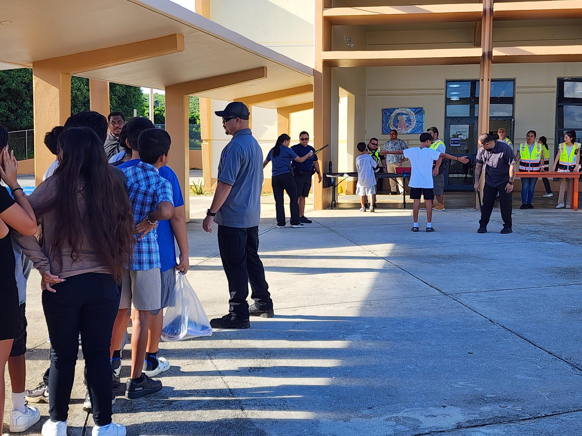 Students wait in line for their turn to be screened at Chacha Ocean View Middle School on Friday.