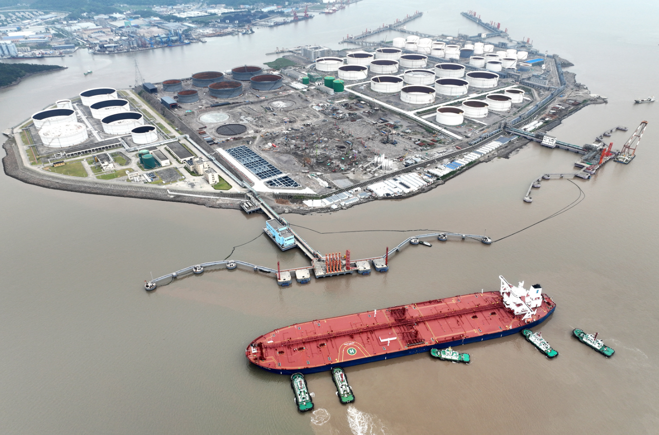 An aerial view shows tugboats helping a crude oil tanker to berth at an oil terminal, off Waidiao Island in Zhoushan, Zhejiang province, China on July 18, 2022.