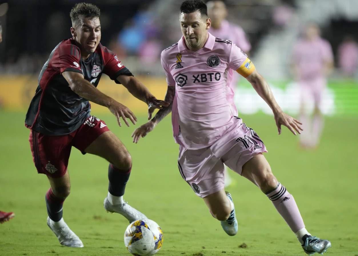 Inter Miami forward Lionel Messi, right, takes the ball past Toronto FC Kobe Franklin during the first half of an MLS soccer match, Wednesday, Sept. 20, 2023, in Fort Lauderdale, Fla.
