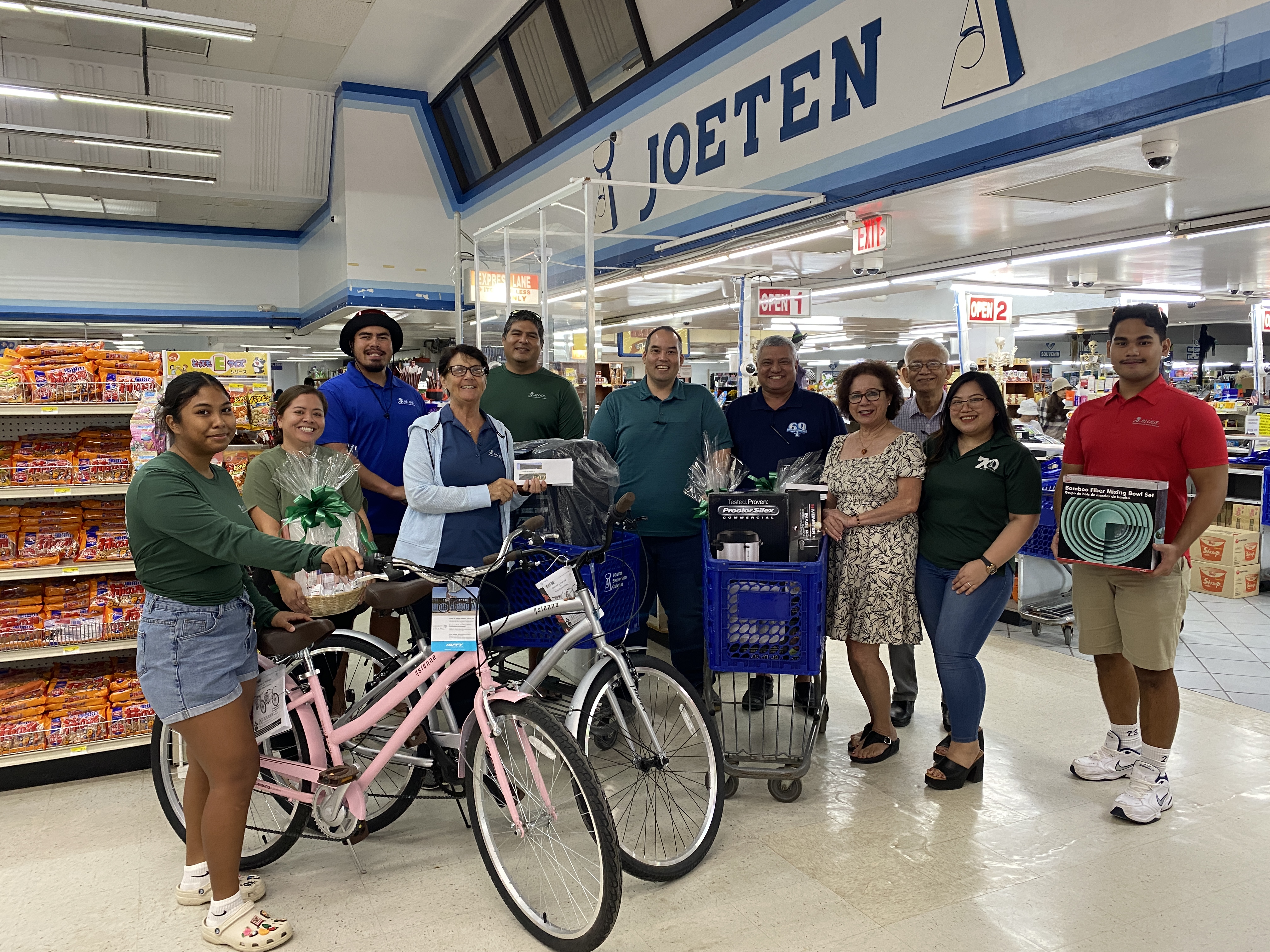 Joeten and MINA staff pose for a photo at Joeten Susupe with the silent auction prizes donated by JC Tenorio Enterprises.
