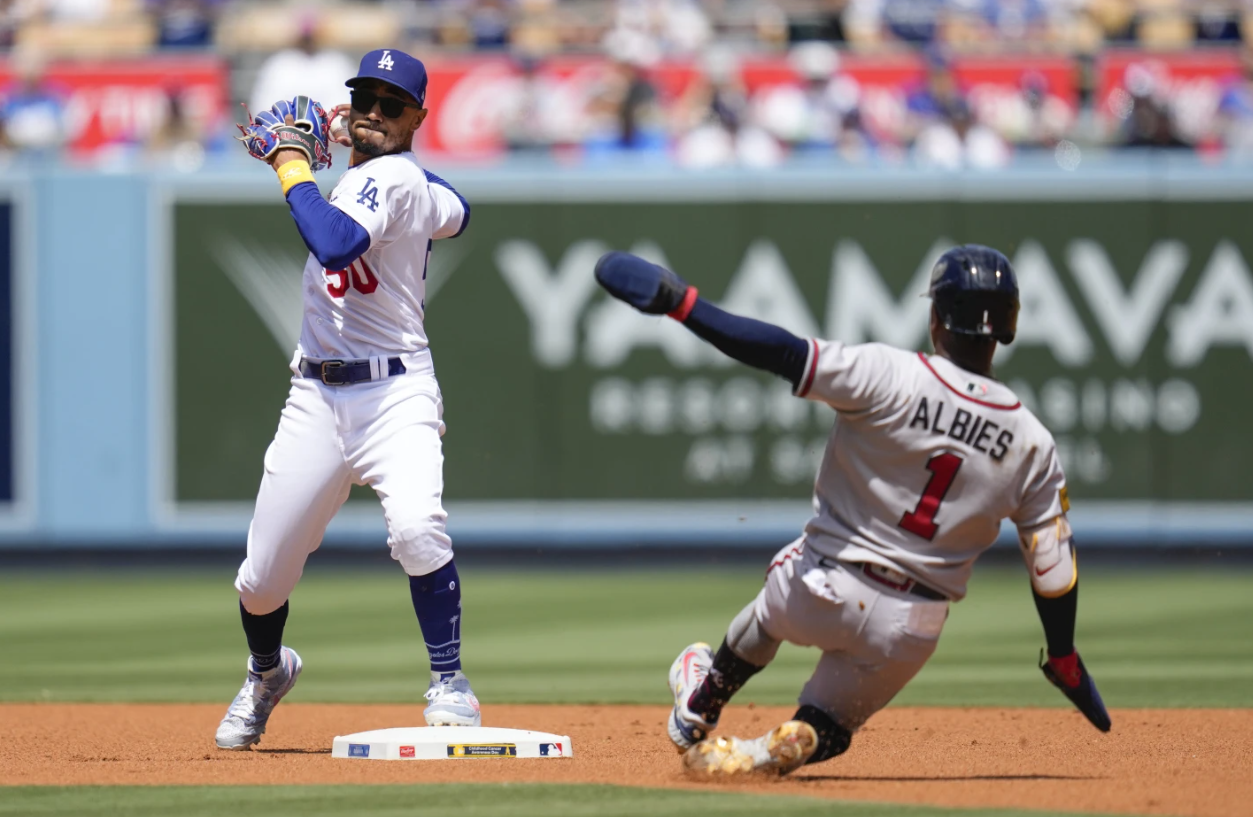 Los Angeles Dodgers second baseman Mookie Betts (50) throws to first after outing Atlanta Braves’ Ozzie Albies (1) at second during the first inning of a baseball game in Los Angeles, Sunday, Sept. 3, 2023. Atlanta Braves’ Austin Riley was safe at first.
