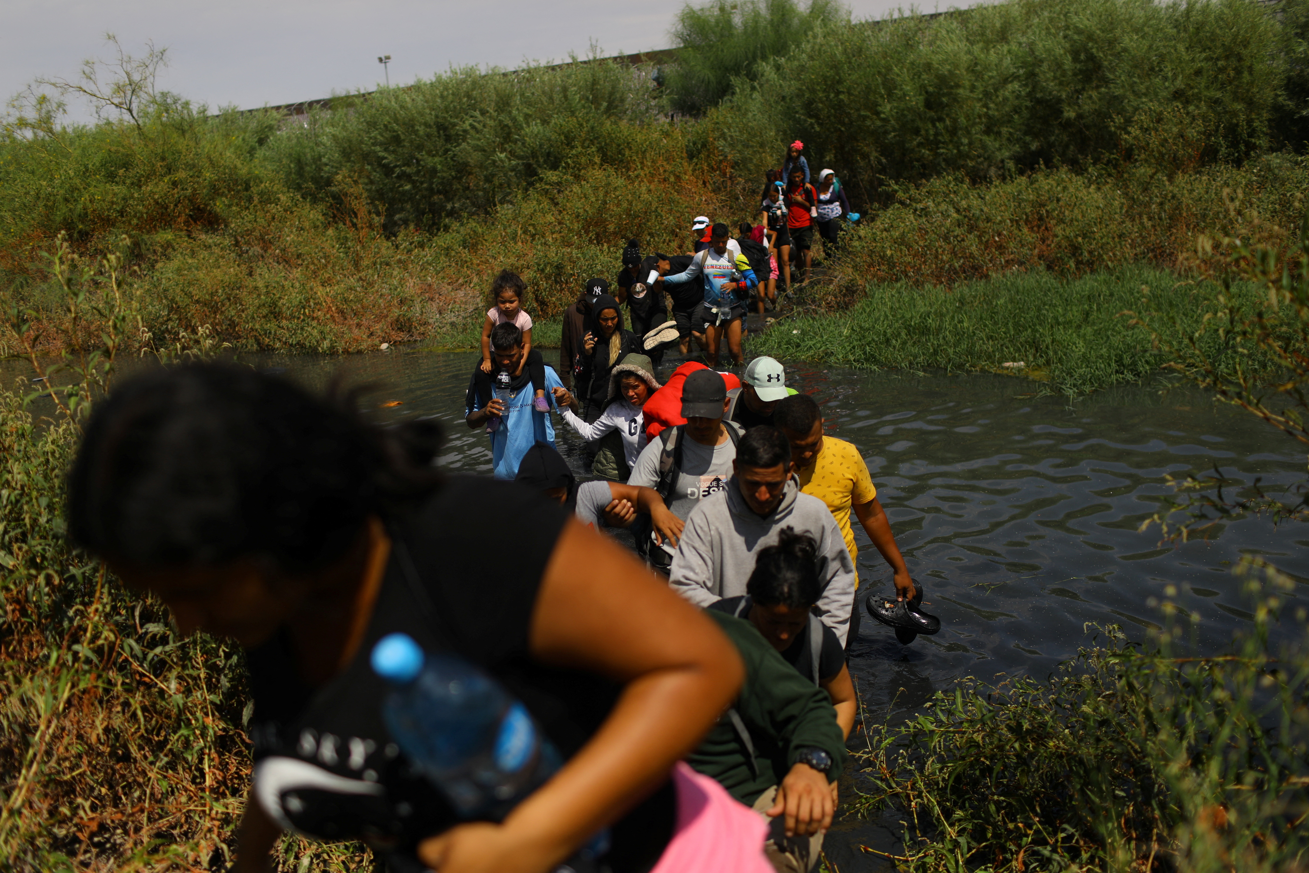 Migrants mostly from Venezuela, seeking asylum in the United States, cross the Rio Bravo river to return to Mexico from the United States, after members of the U.S. Texas National Guard extended razor wire to inhibit migrant crossing, as seen from Ciudad Juarez, Mexico, September 21, 2023. 