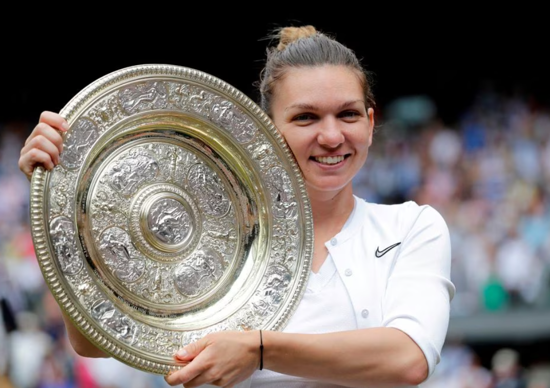 Romania's Simona Halep poses with the trophy as she celebrates after winning the final against Serena Williams of the U.S. at Wimbledon in London, Britain, July 13, 2019