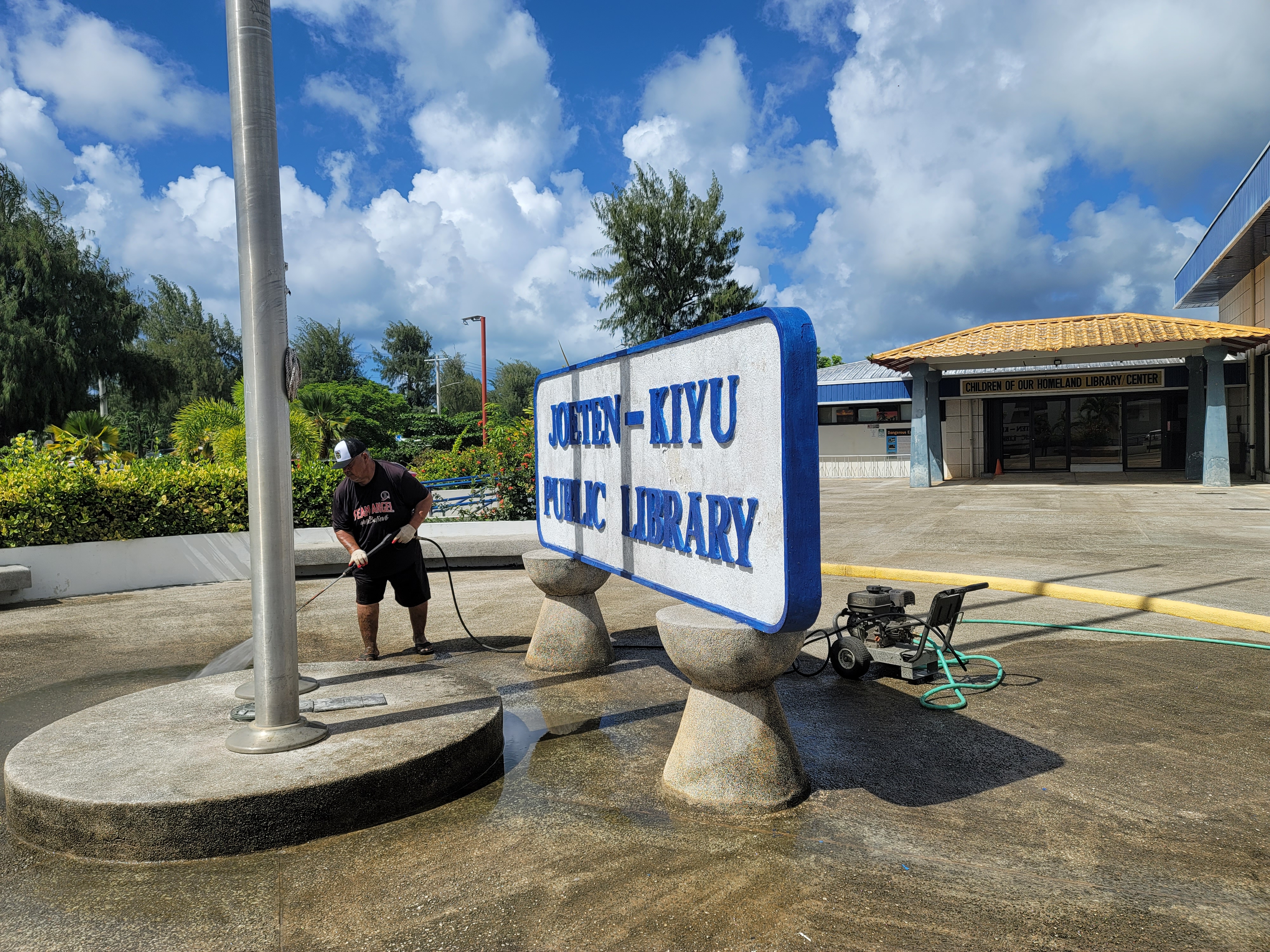 Juan C. Lizama from the office of Rep. John Paul Sablan water-blasts the JKPL courtyard.