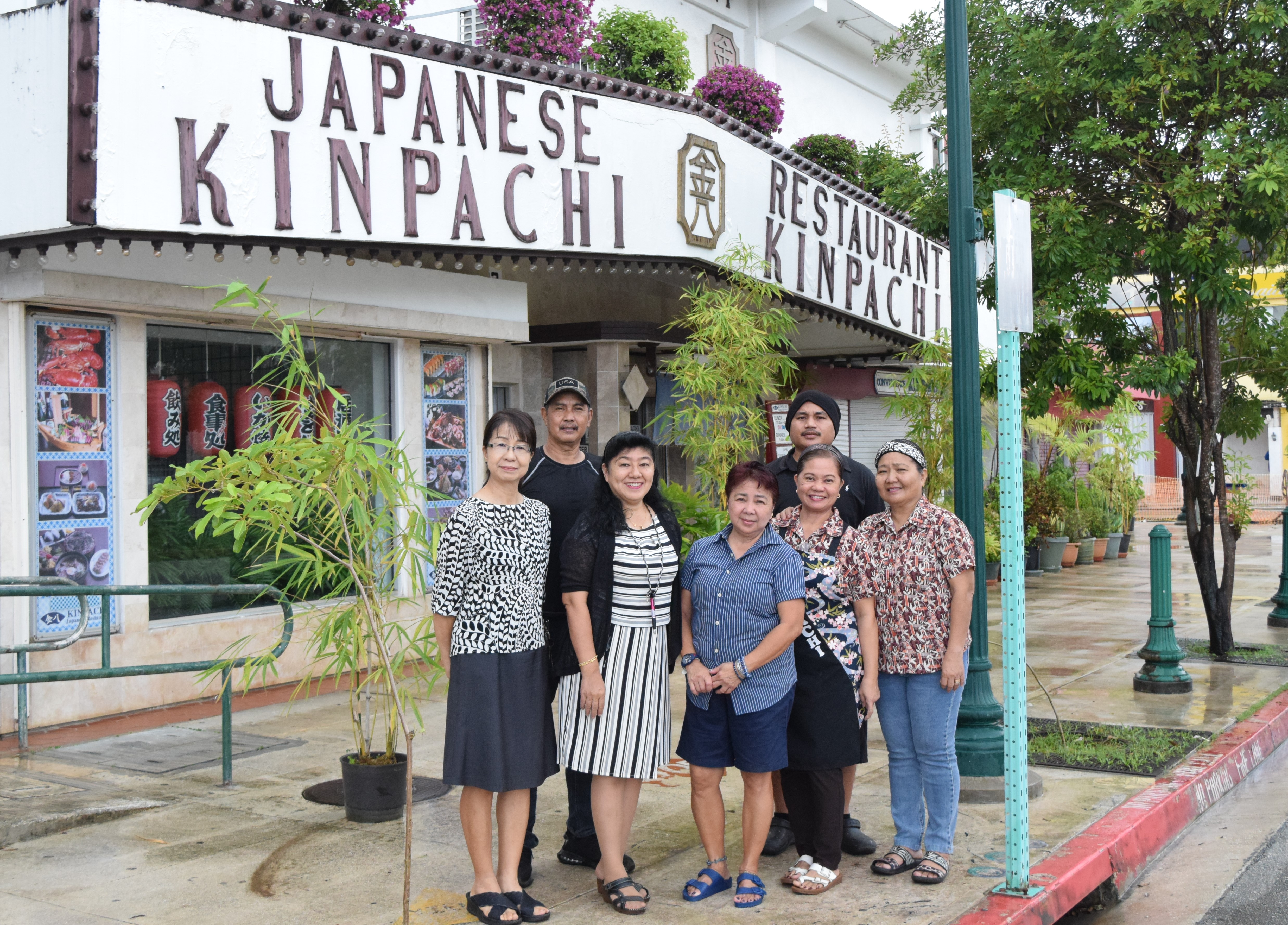 Kinpachi Japanese Restaurant owner Misako Kamata, third left, with staff member Sonia Siwa, center; manager Yoshiko Song, left; maintenance worker Alberto Ignacio, second left; food server Vangie Lagmay, second right; cook Zacarias Sakisat, backrow; and accountant Priscilla Mendoza pose for a photo outside the restaurant on Friday last week.
