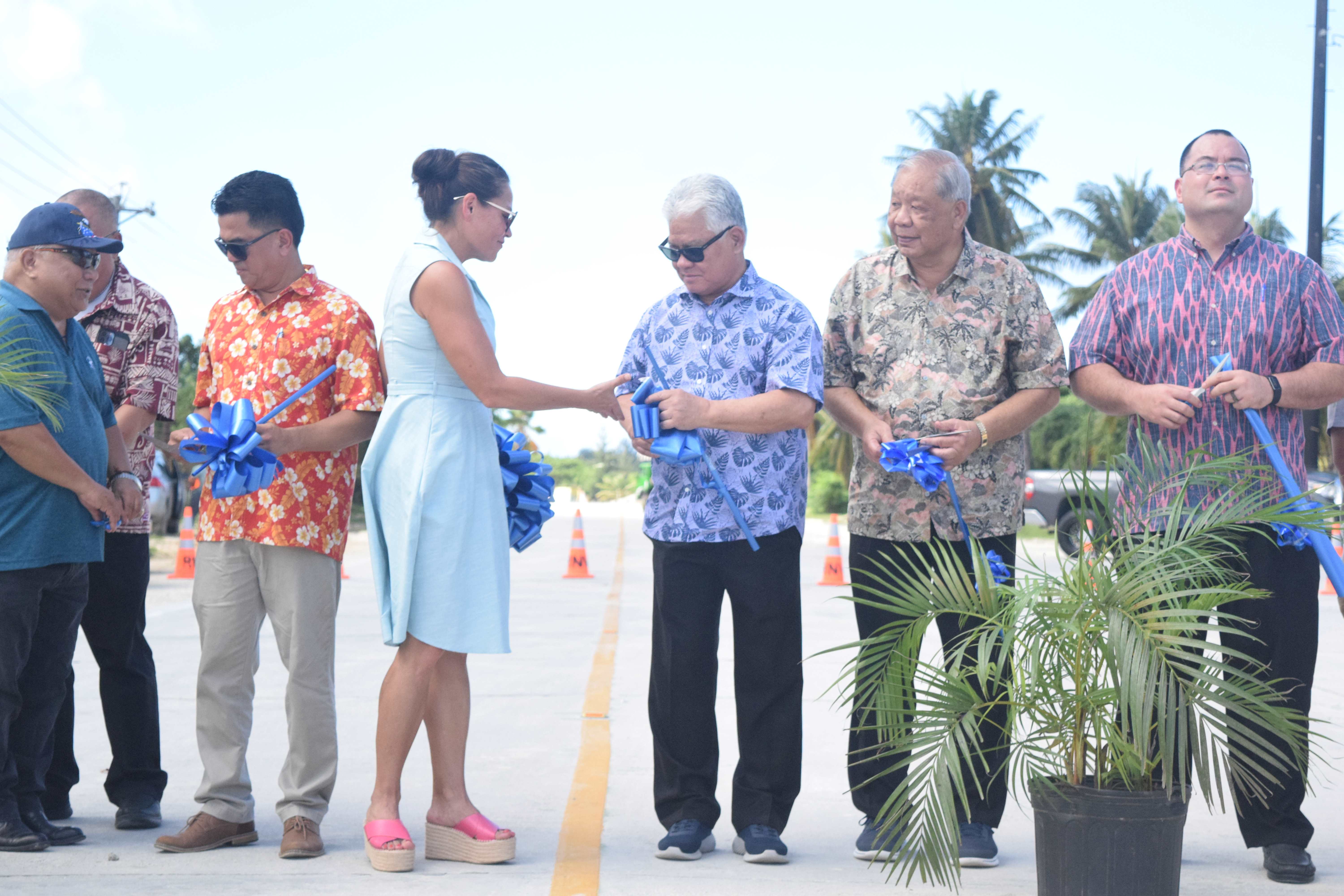 Commonwealth Ports Authority Board Chair Kimberlyn King-Hinds, fourth left, extends her hand to Gov. Arnold I. Palacios as Lt. Gov. David M. Apatang, second right, looks on. Also in the picture are CPA board member Antonio B. Cabreral, left, CPA Executive Director Christopher Tenorio, second left, Department of Public Works Secretary Ray N. Yumul, third left, and Speaker Edmund S. Villagomez, right, during the ribbon-cutting ceremony for the opening of the newly paved Industrial Drive in Puerto Rico on Friday.